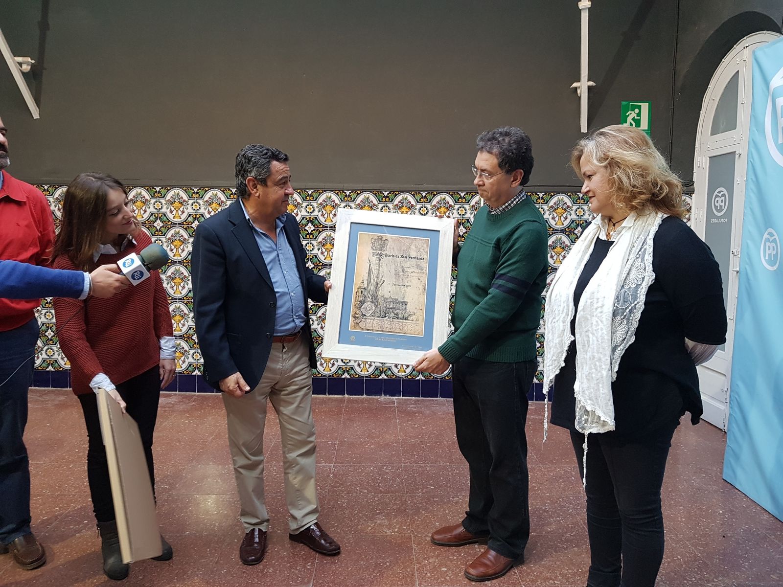 Paco López (d.) recibe la distinción por su labor periodística por parte de José Loaiza.