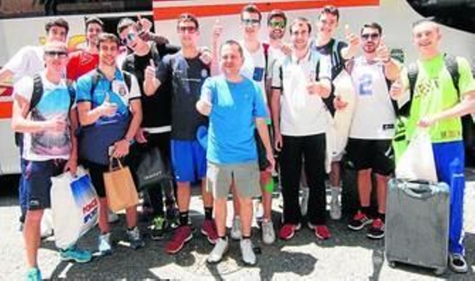 Rafa Sanz y sus jugadores, pulgar arriba, antes de partir en autocar hacia León.