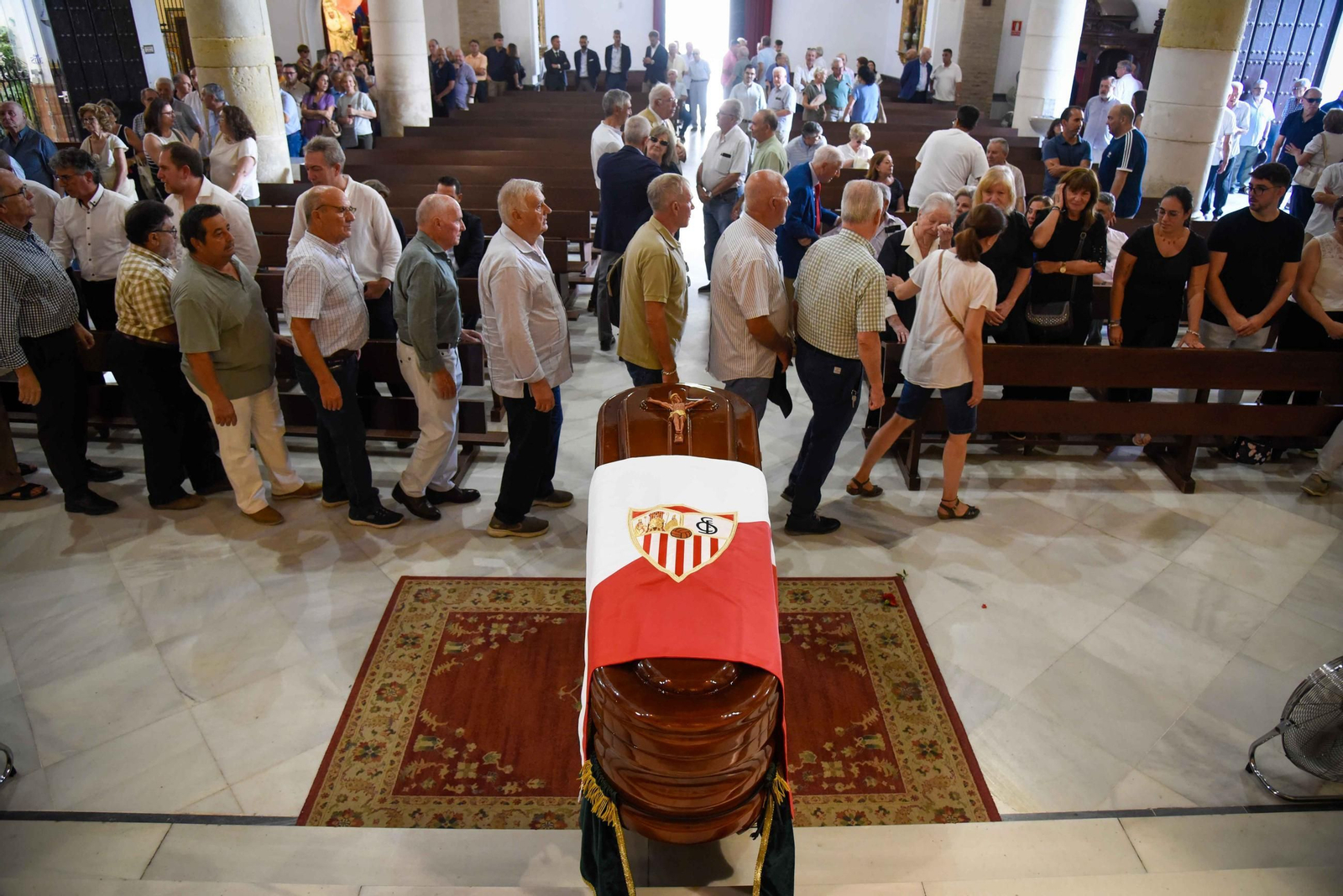 Momento del pésame ante el féretro de Manolo Cardo, con la bandera del Sevilla.