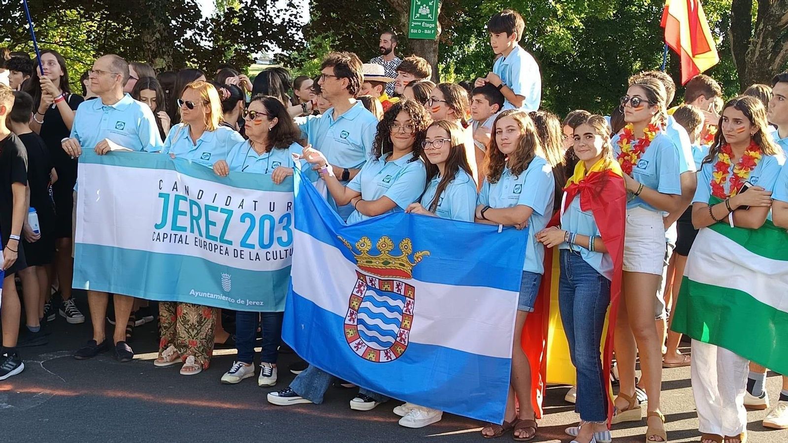 La delegación jerezana, con Magdalena Garrido a la cabeza, luciendo las banderas de Jerez y de la candidatura.