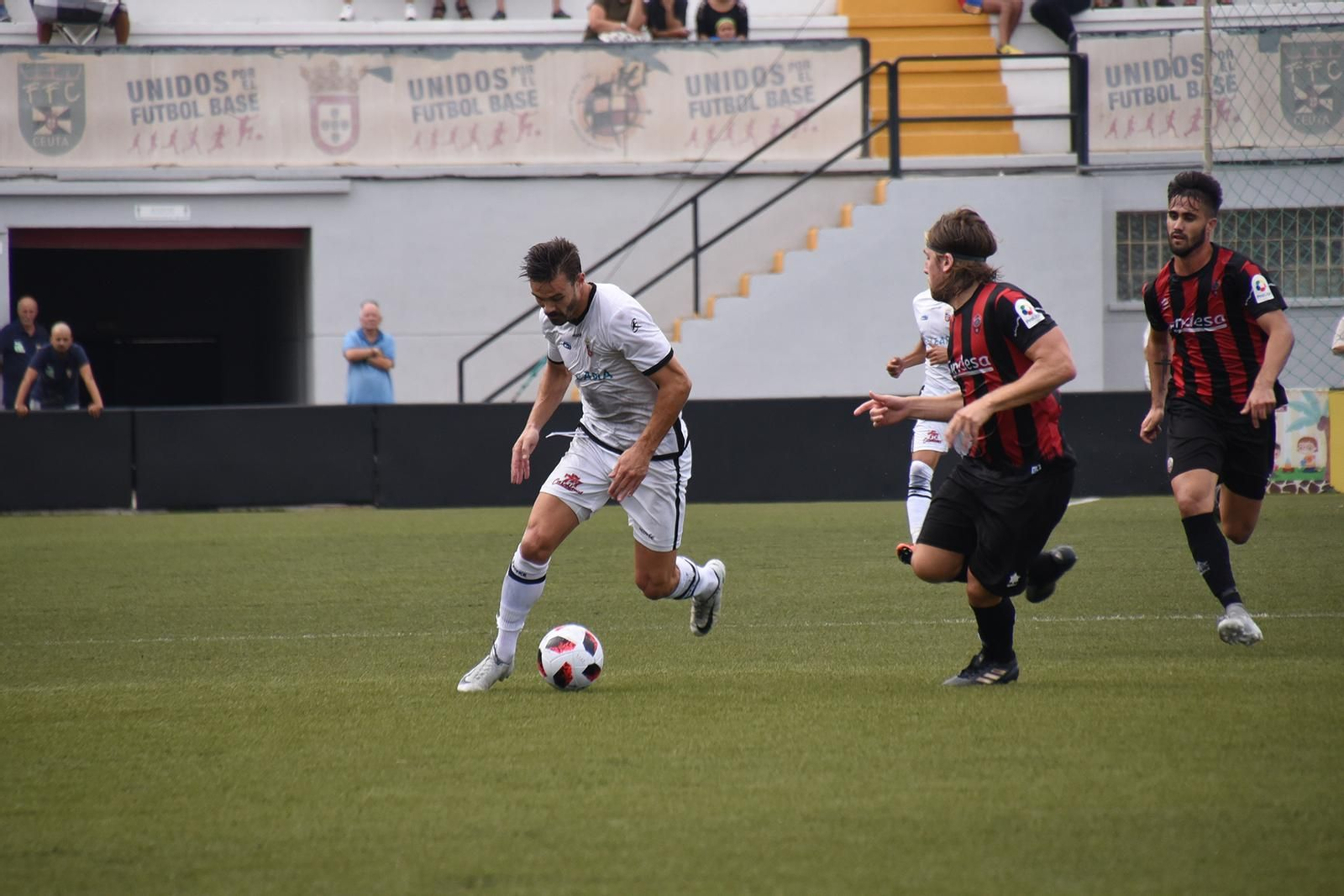 Chico Díaz se marcha de dos defensores en un encuentro con el Ceuta.