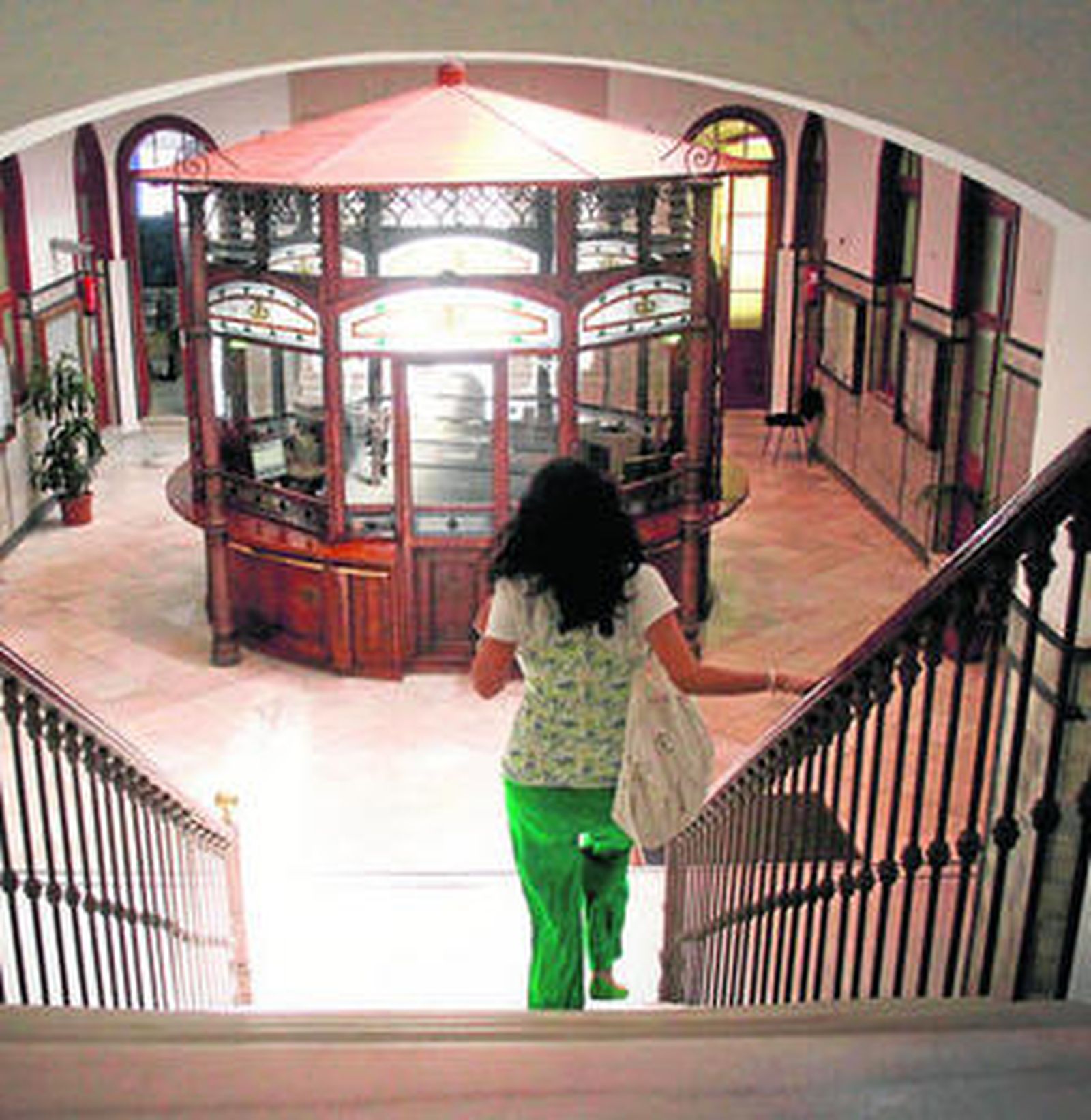 Una mujer baja la escalera que conduce al vestíbulo principal del Ayuntamiento.