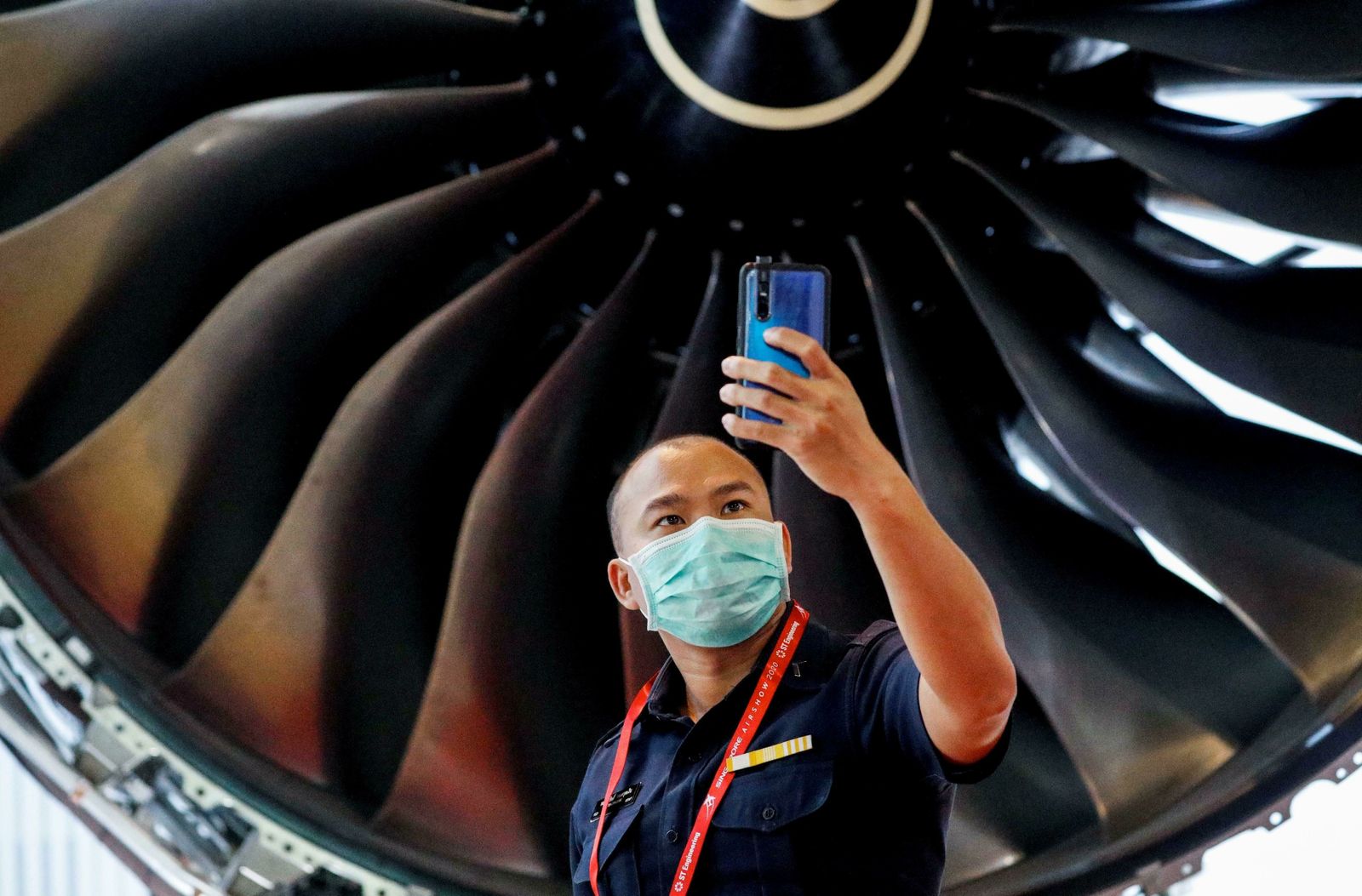 Un hombre protegido con una mascarilla se hace una foto este martes en Singapur durante la feria de aviación.