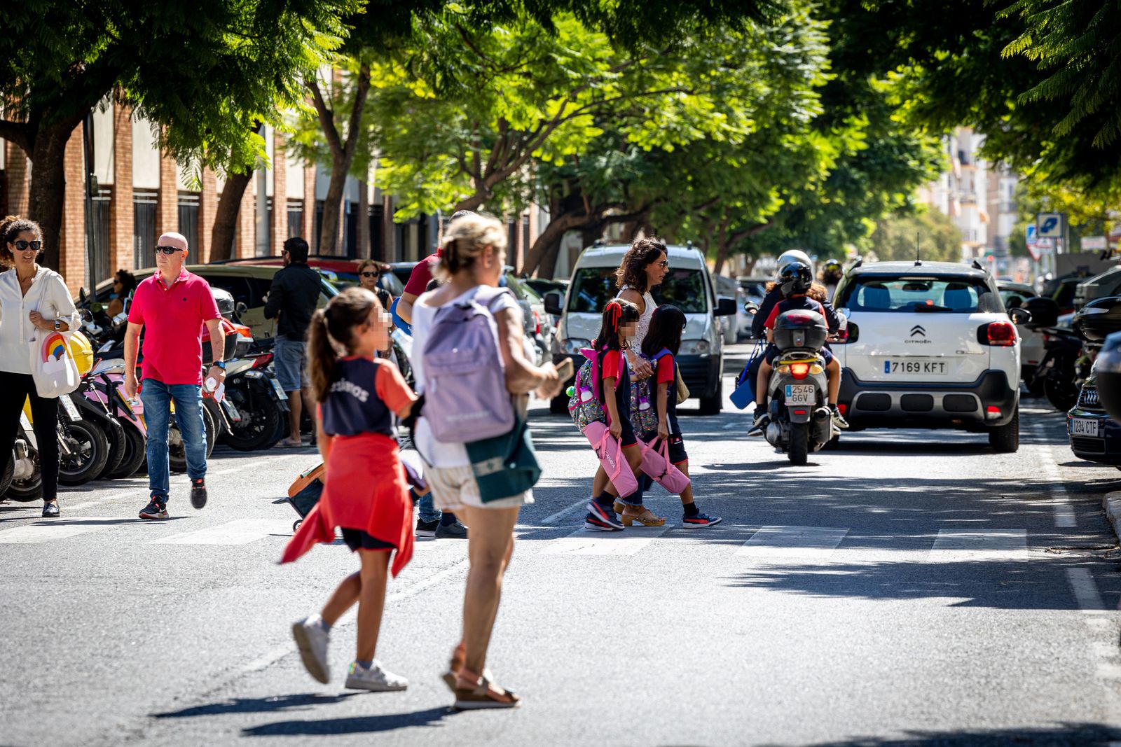 Escolares, algunos acompañados por sus padres, cruzando la Avenida María Auxiliadora, a la salida de clase.