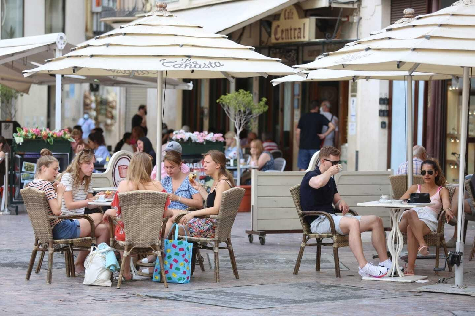 Varias personas en una terraza de Málaga.