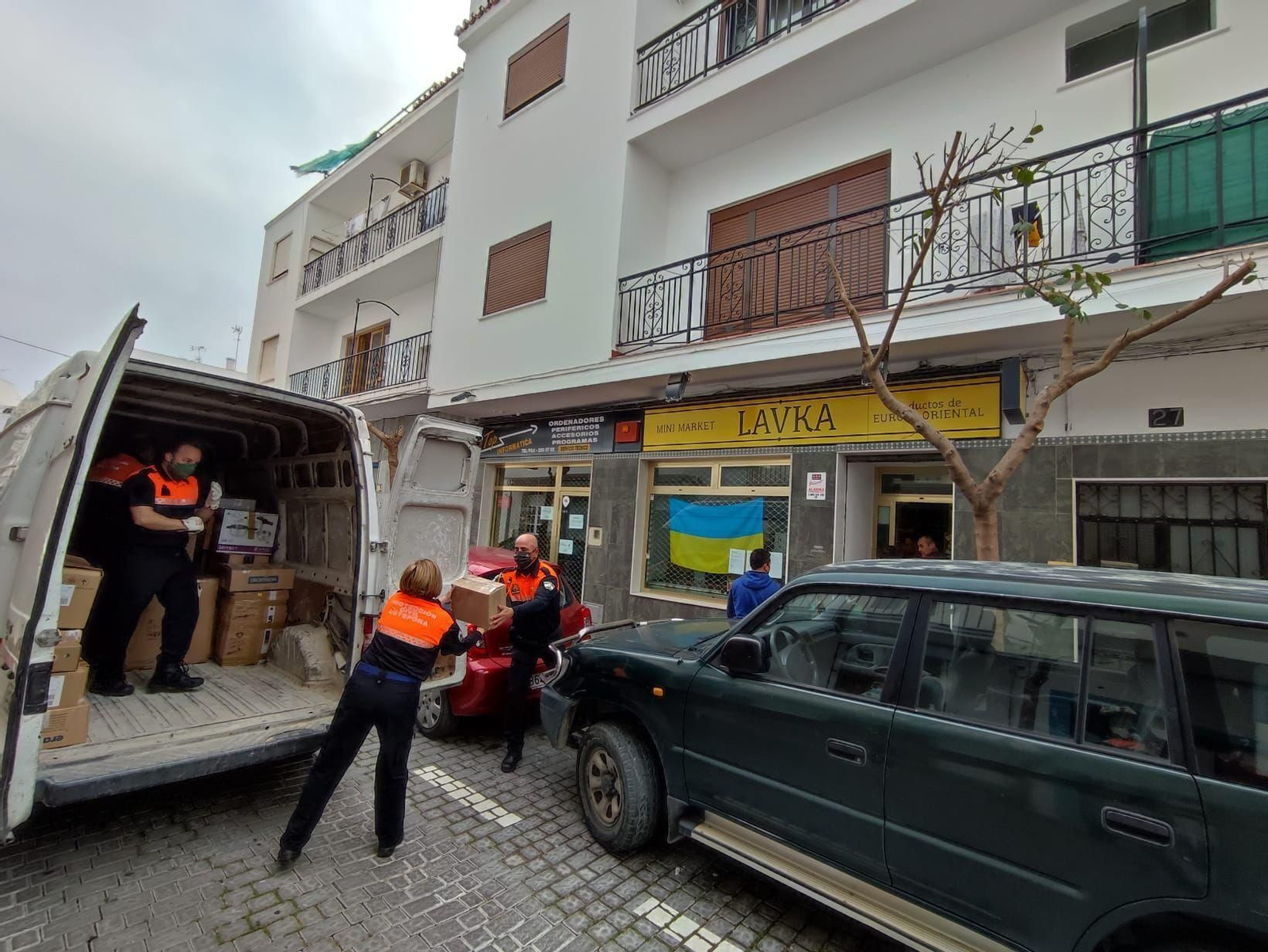 Voluntarios de Protección Civil de Estepona repartiendo enseres.