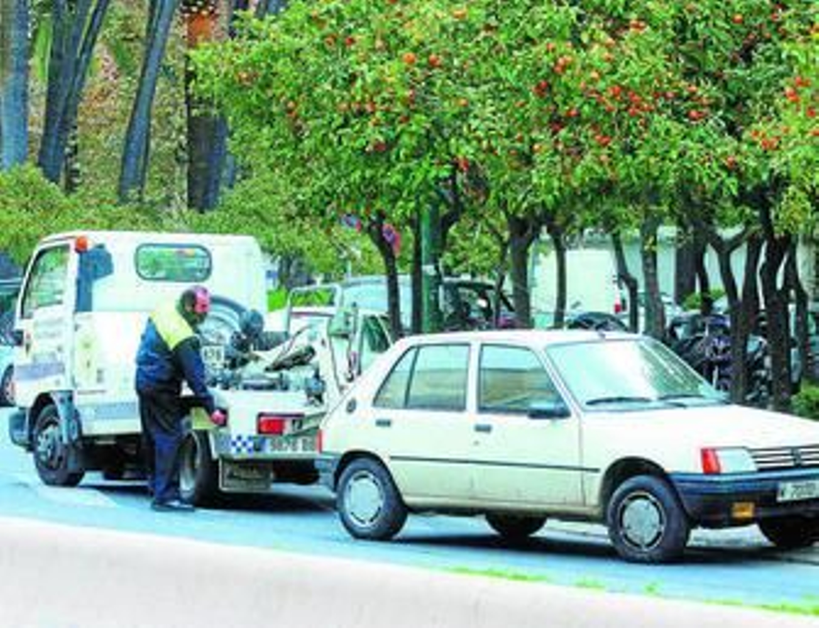 Una grúa municipal retira un vehículo mal aparcado.