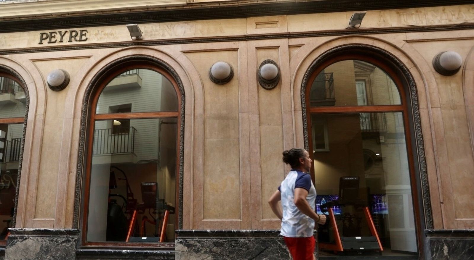 Una mujer pasa delante de los escaparates del antiguo Peyré, ya con las cintas de correr instaladas.