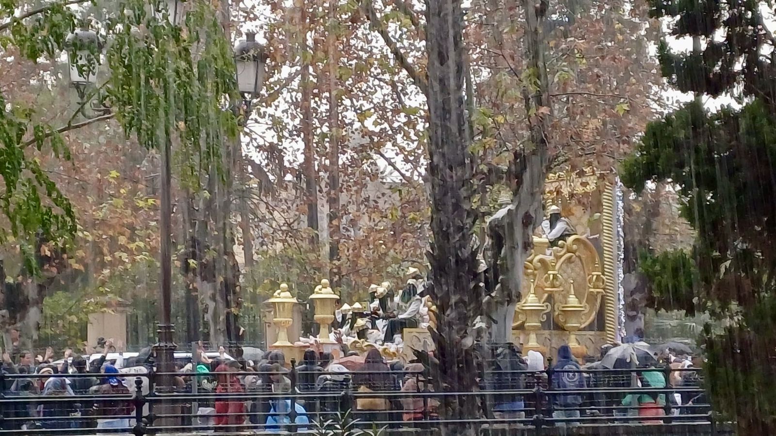 La carroza de Baltasar en la calle Palos de la Frontera bajo una manta de agua.
