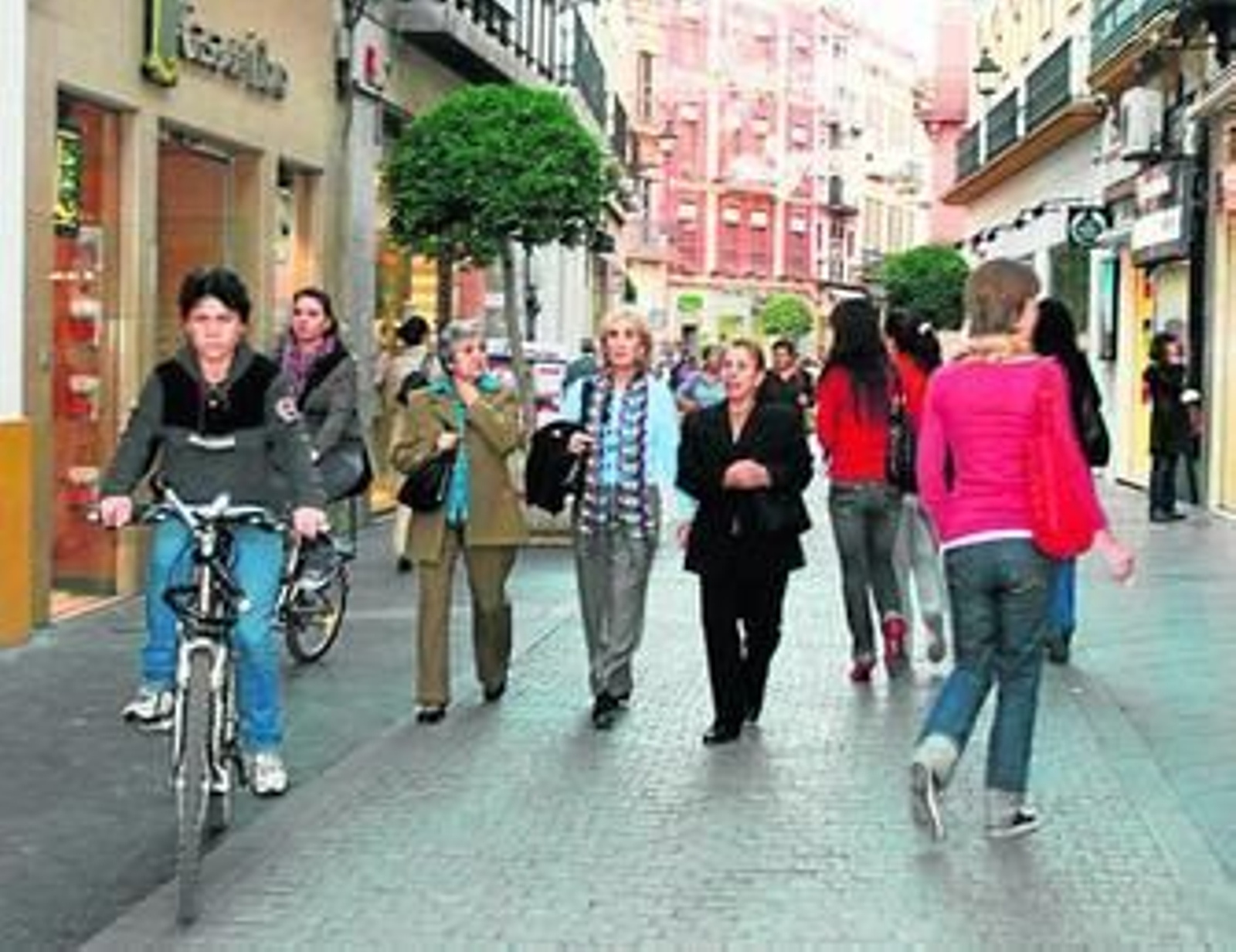 Varios ciclistas circulan por una calle del centro junto a los peatones.