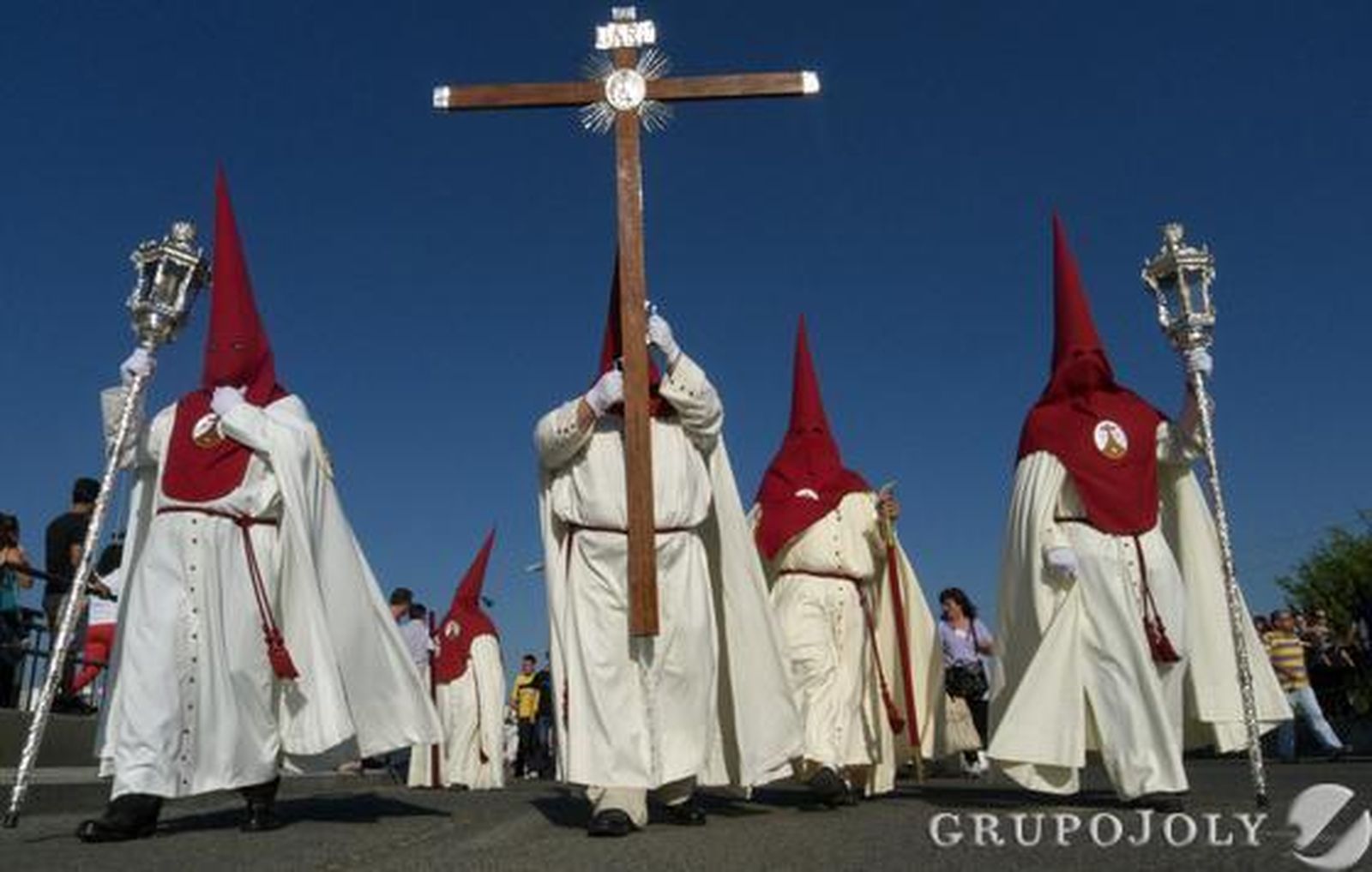 Los nazarenos de la Hermandad de Padre Pío Palmete recorren el barrio.  Foto: Juan Carlos Muñoz