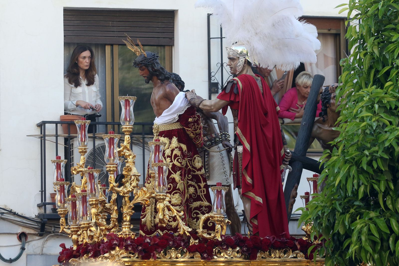 Una mujer contempla el paso de El Gitano desde un balcón.