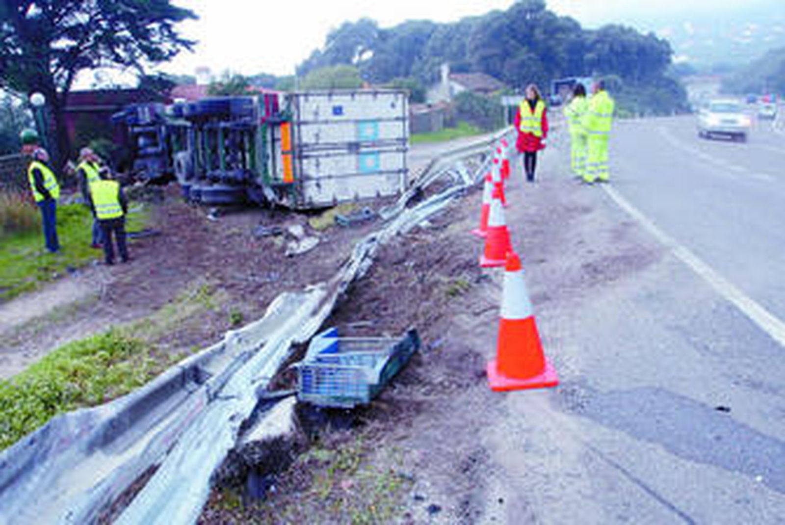 Al fondo, el camión volcado poco después del accidente.