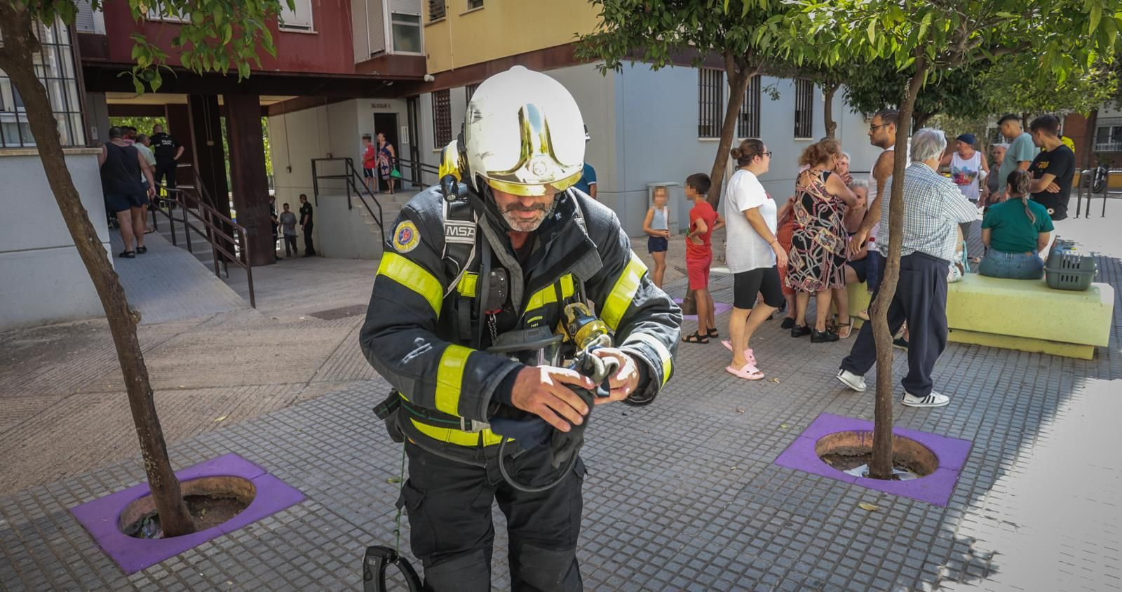 Un bombero, junto a los vecinos del bloque de la vivienda afectada. Un bombero, junto a los vecinos del bloque de la vivienda afectada.