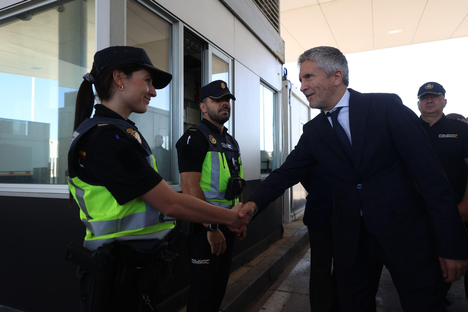 El ministro del Interior, Fernando Grande-Marlaska, saluda a una agente de Policía en el Puerto de Algeciras.