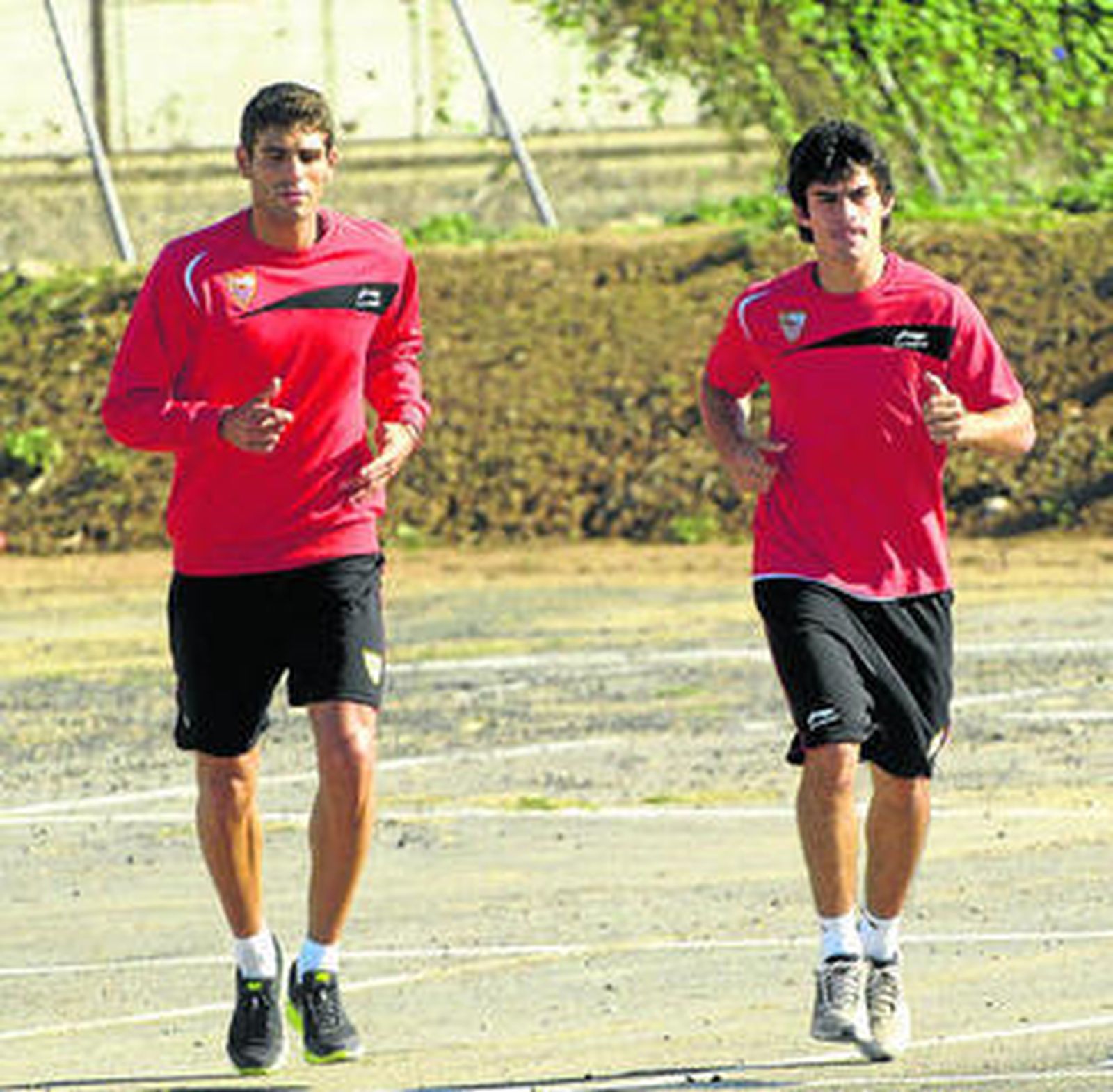1. Perotti corre junto a Fazio durante la sesión de entrenamiento, que incluyó un circuito fuera de la ciudad deportiva, por la Universidad Pablo de Olavide.  2. Monchi y Marcelino, a la salida de su charla en el gimnasio. 3. Con nuevo peinado, Spahic sonríe en la rueda de prensa previa al Bosnia-Portugal. 4. Manu del Moral y Campaña encabezan un grupo sobre la pasarela que une la ciudad deportiva con la UPO.