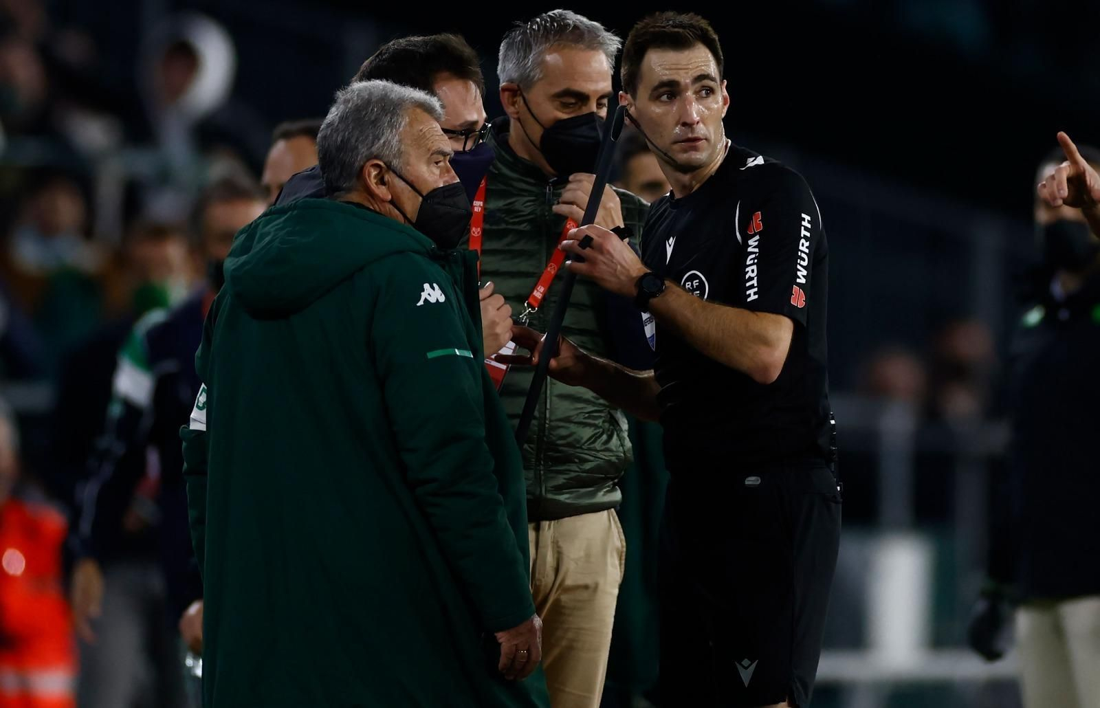 El árbitro del encuentro le da el objeto lanzado al delegado del Betis.
