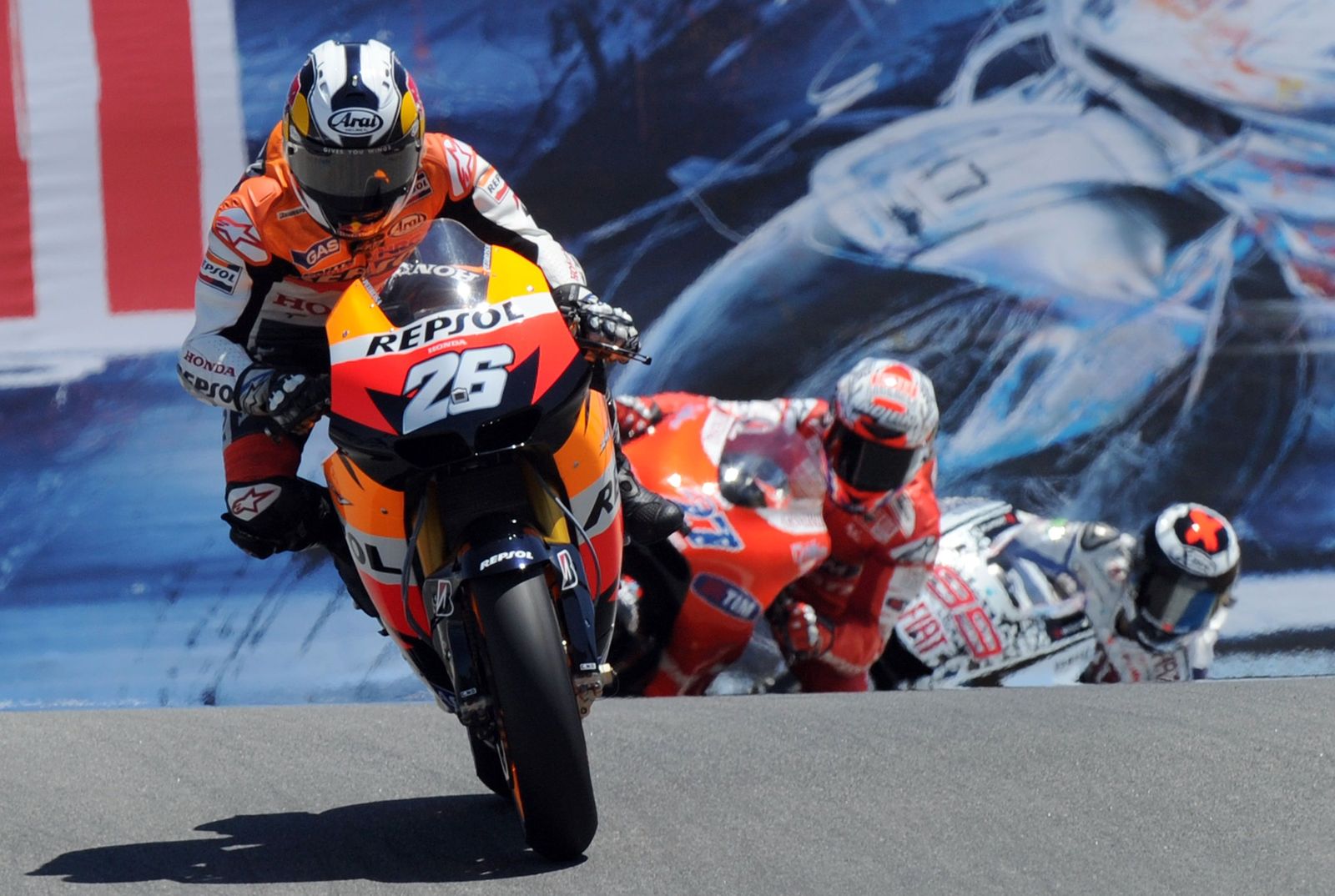 El piloto de Honda, Dani Pedrosa adelantando a Stoner y Lorenzo antes de su caída. 

Foto: GABRIEL BOUYS.
