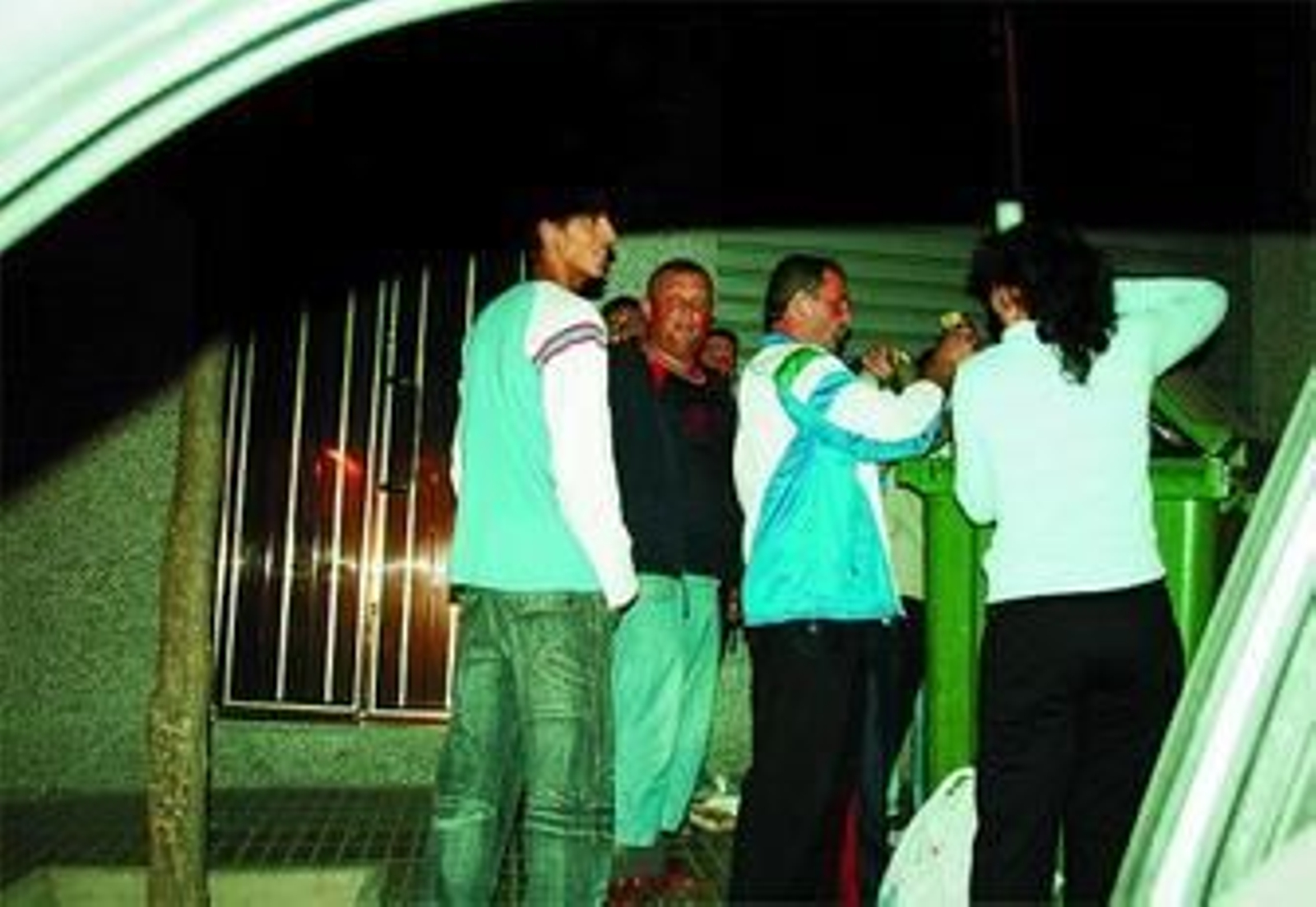 Un grupo de personas busca en los cubos de la basura de Antequera el pasado viernes.