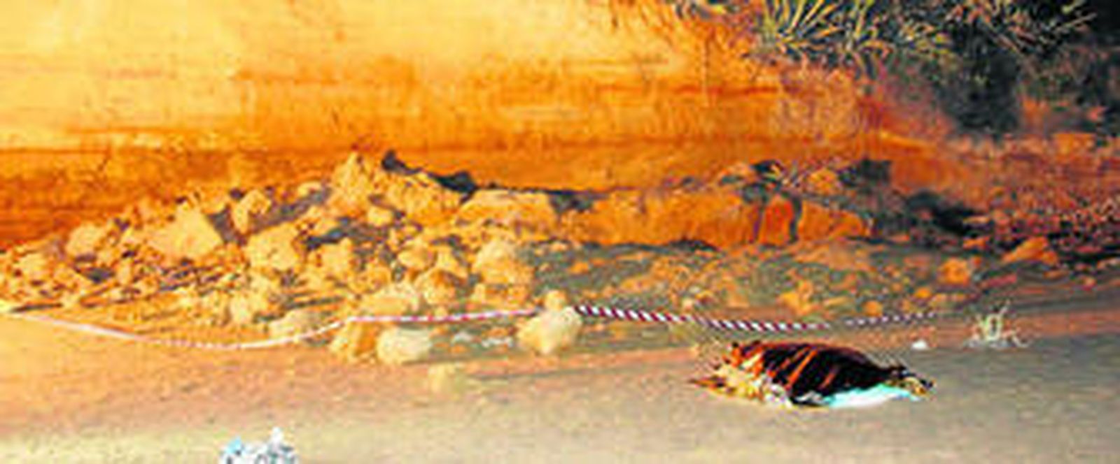 El cadáver de María José Cabello yace tapado junto a algunas de las piedras que se desprendieron del acantilado, a última hora de la tarde del viernes.