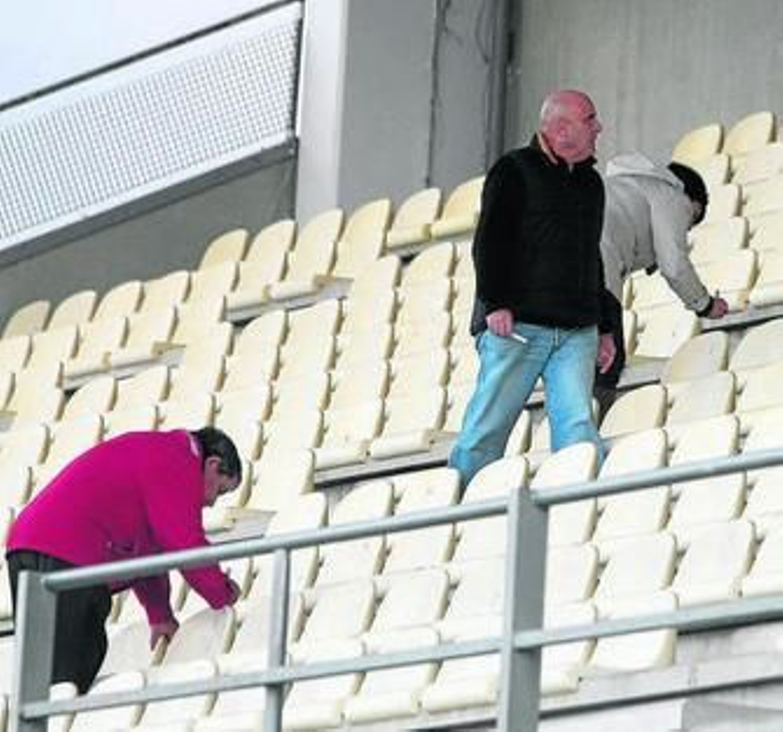 Unos operarios numeran asientos, ayer por la tarde.