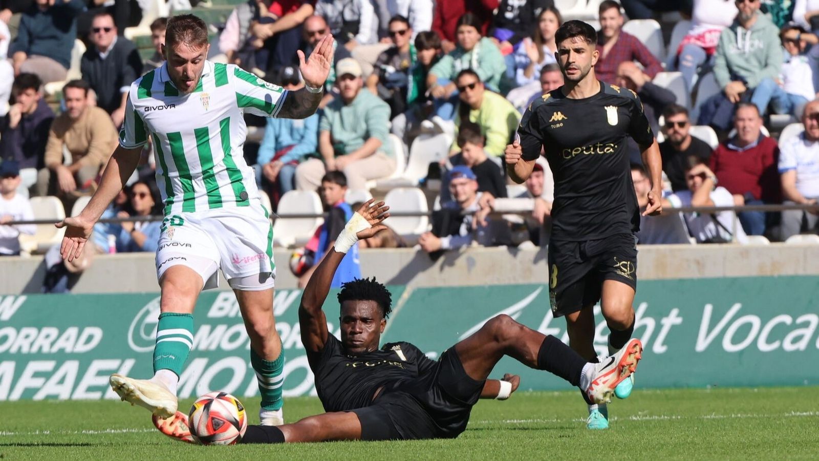 Saturday Erimuya intenta parar un ataque de Casas en un Córdoba CF - Ceuta de 2023.