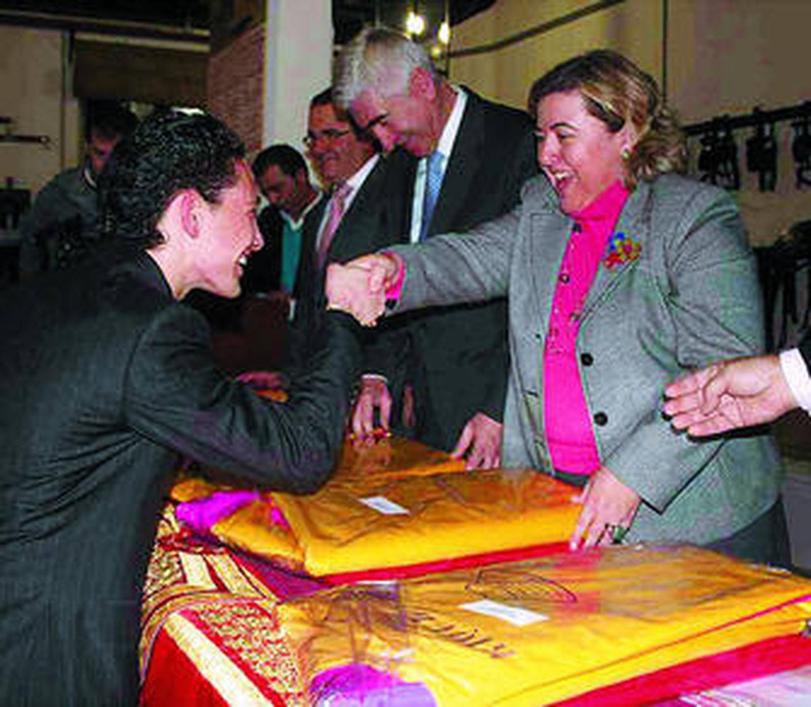 La consejera de Gobernación hace entrega de un capote a uno de los alumnos de la provincia.