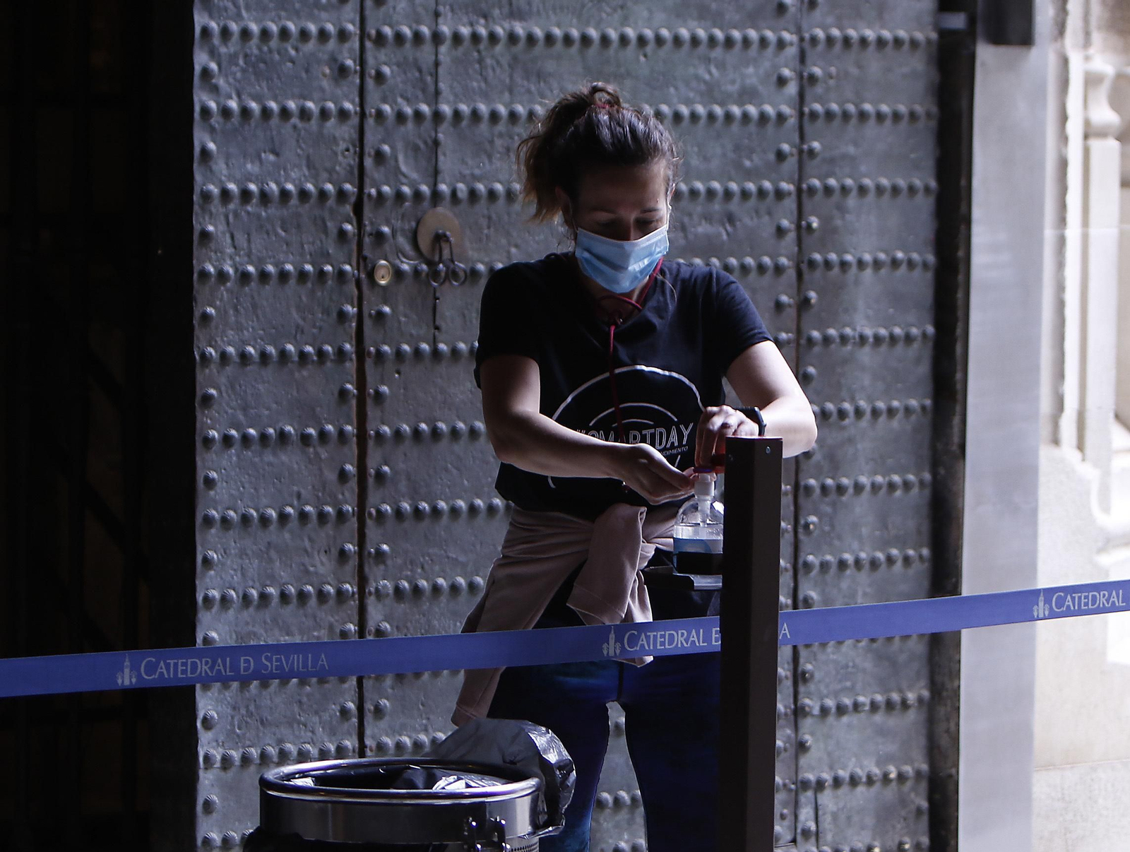 Una joven utiliza un dispensador de gel situado a la entrada de la Catedral de Sevilla.