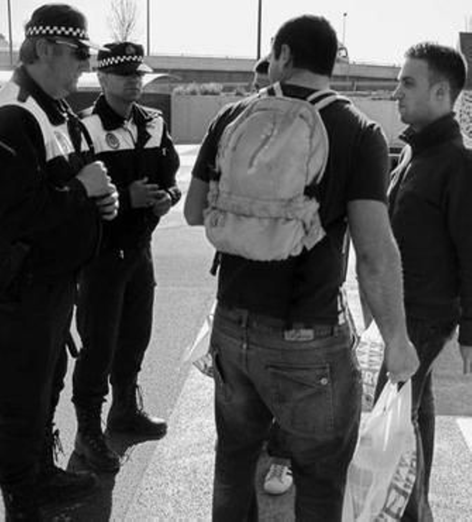 Una pareja de policías charla con un grupo de jóvenes que se dispone a hacer botellón.