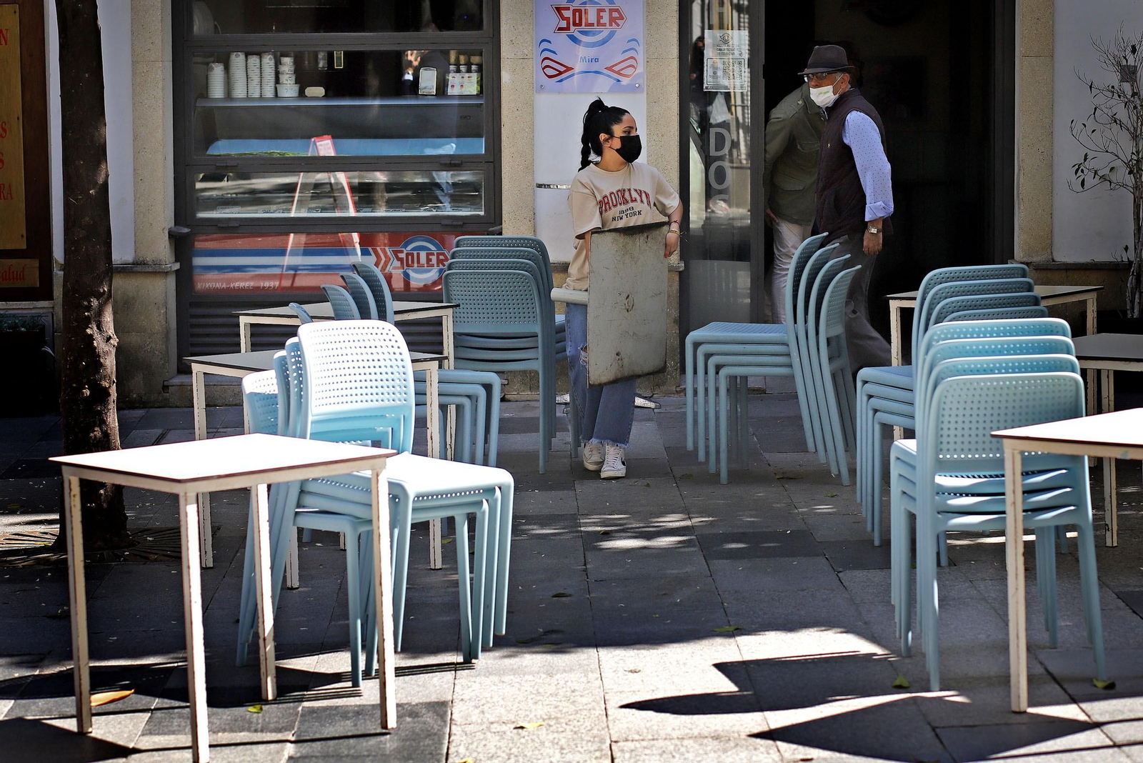 Una empleada de una heladería monta ayer los veladores.