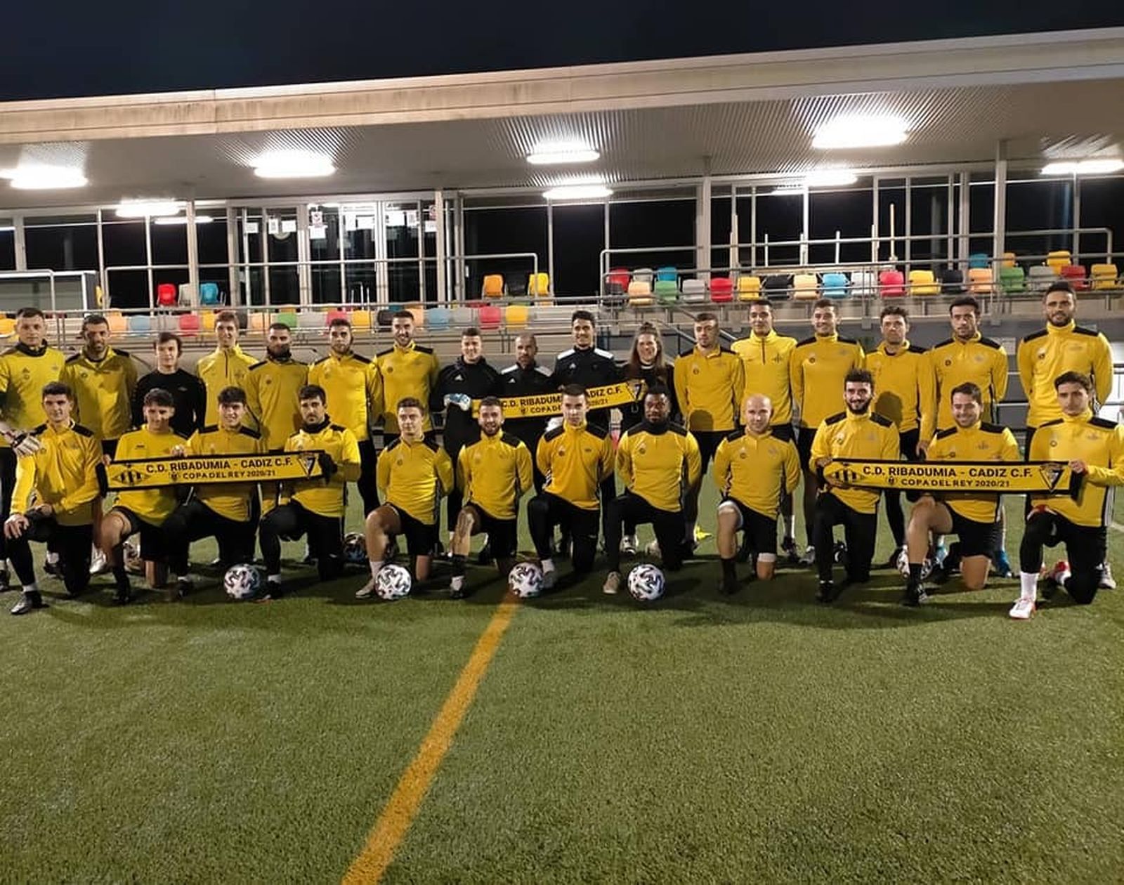 El plantel del Ribadumia, con bufandas del partido de Copa.