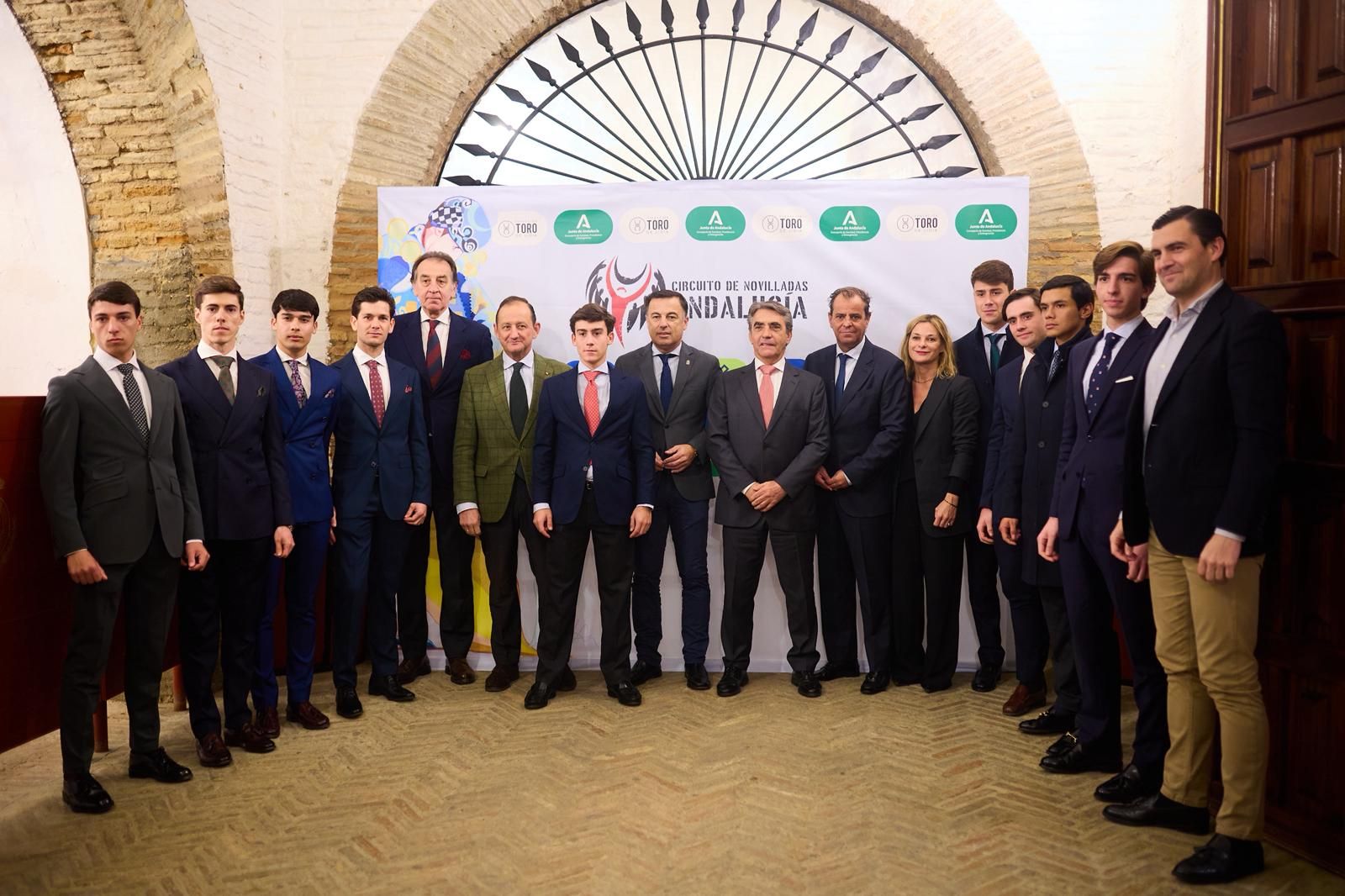 Novilleros, autoridades y patrocinadores posan en la plaza de la Maestranza.