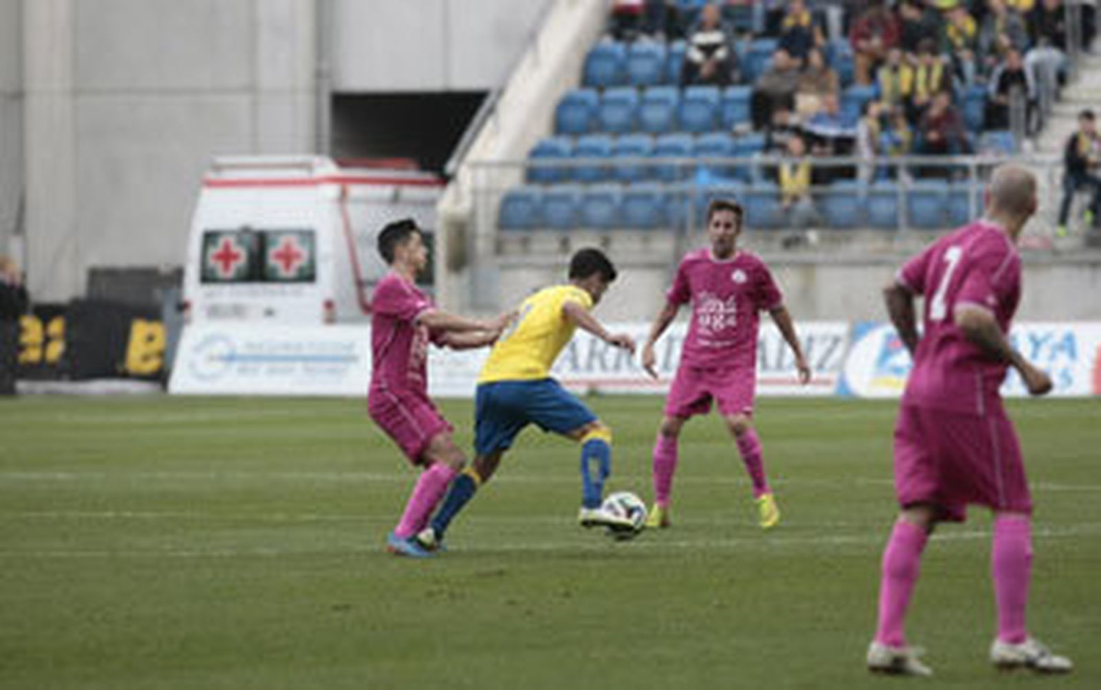 Juanma Espinosa, rodeado por dos contrarios en el partido contra El Palo./Fito Carreto