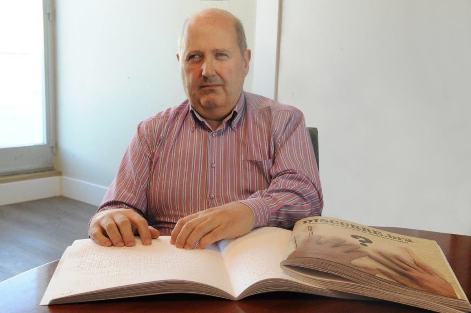 Usuario de la ONCE leyendo braille.