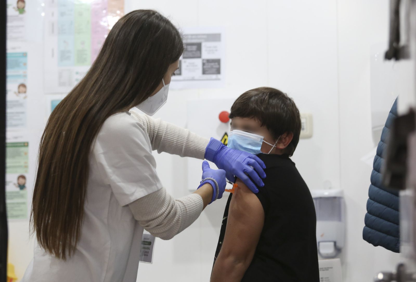 Una enfermera vacuna a un niño.