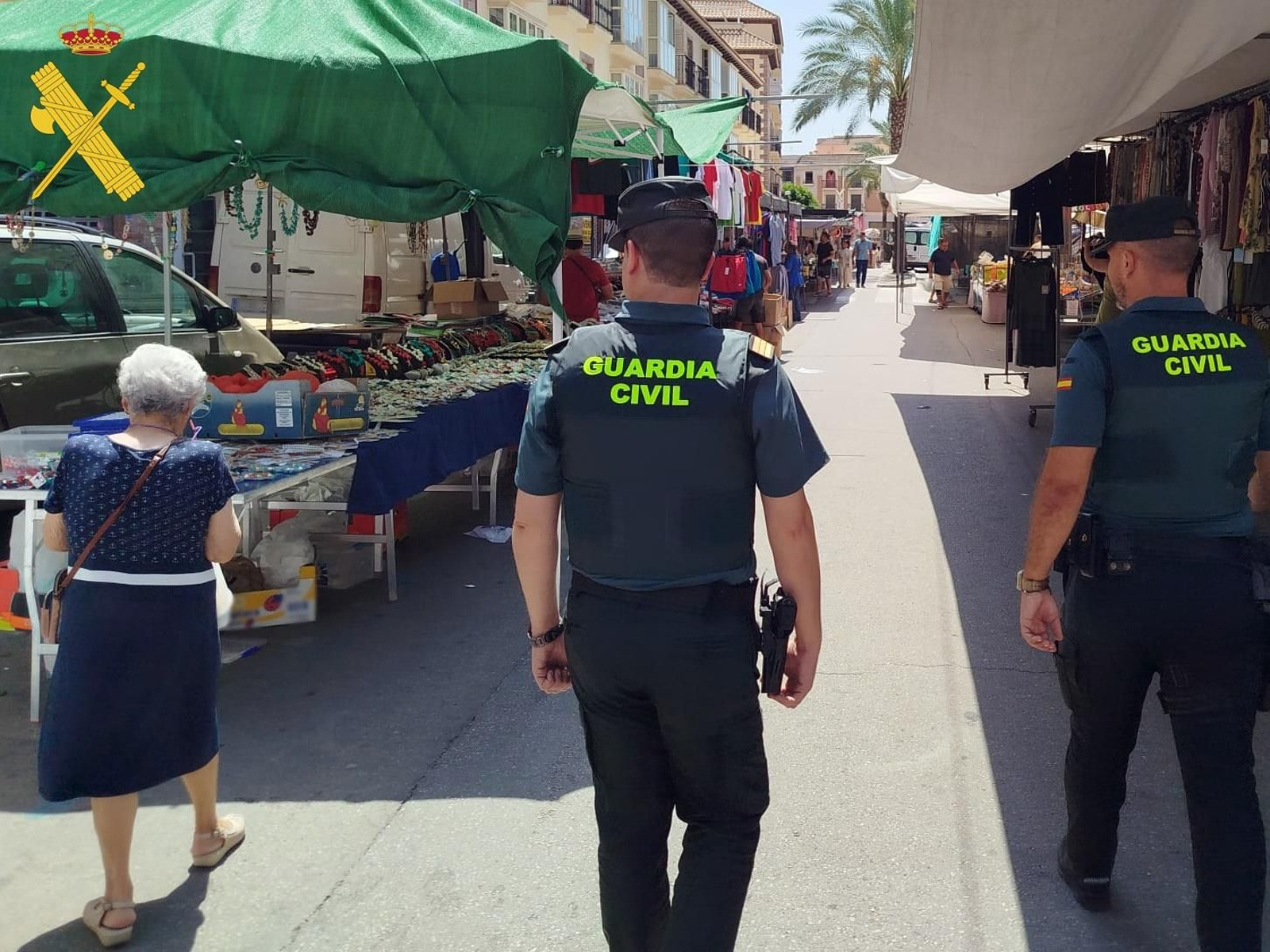 Agentes de la Guardia Civil patrullan por un mercadillo.