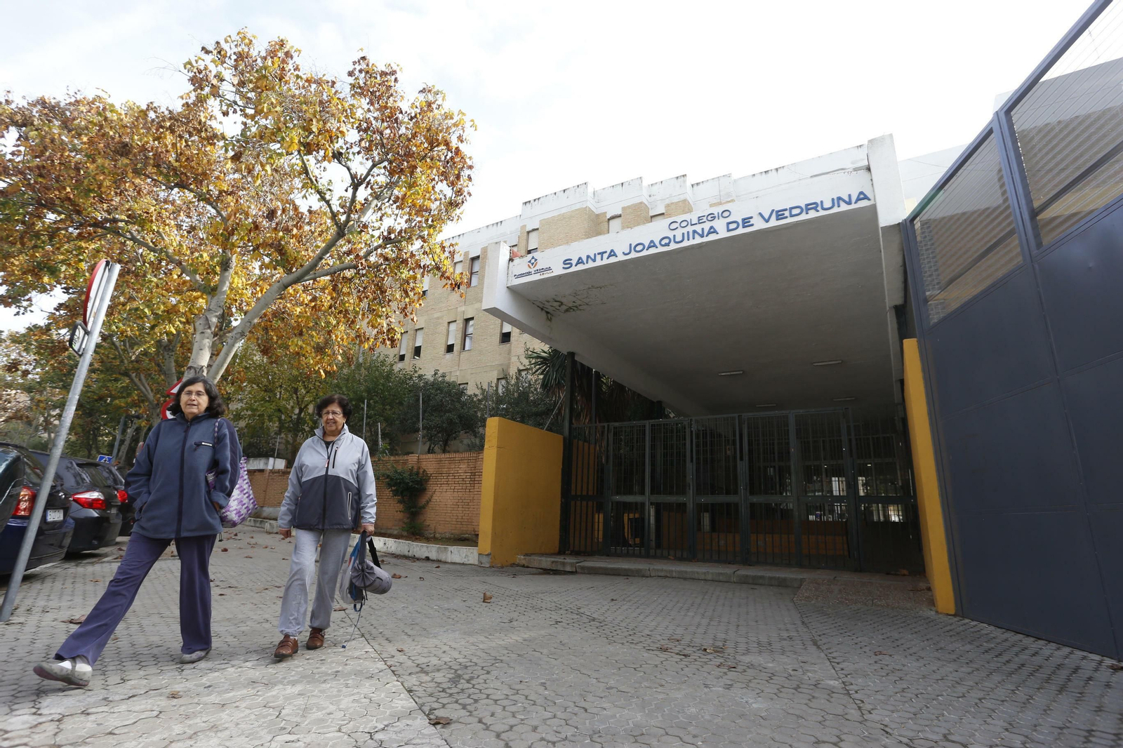 Dos mujeres pasan por la puerta principal del colegio Santa Joaquina de Vedruna.