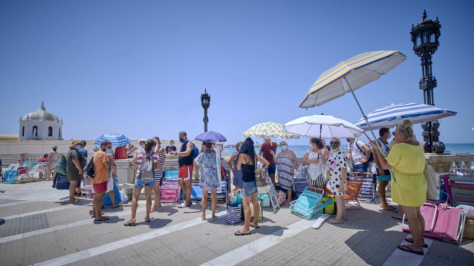Bañistas hacen cola para acceder a la playa de La Caleta de Cádiz mientras que estaba completo el aforo.