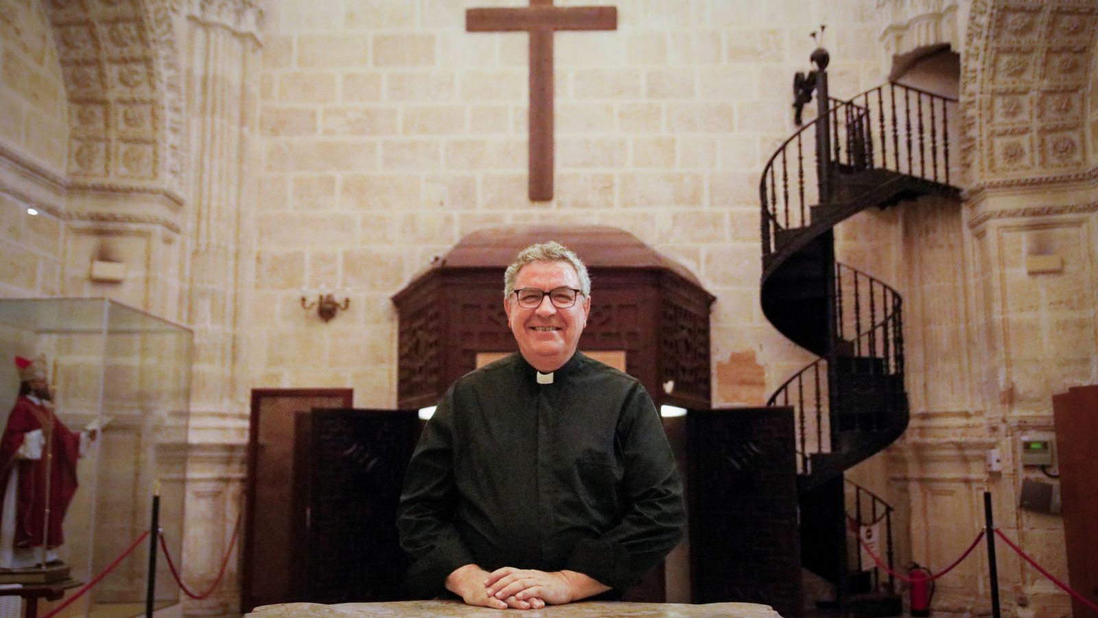 El deán, en la sacristía ante la cruz que se colocó en el comienzo de la construcción del templo.