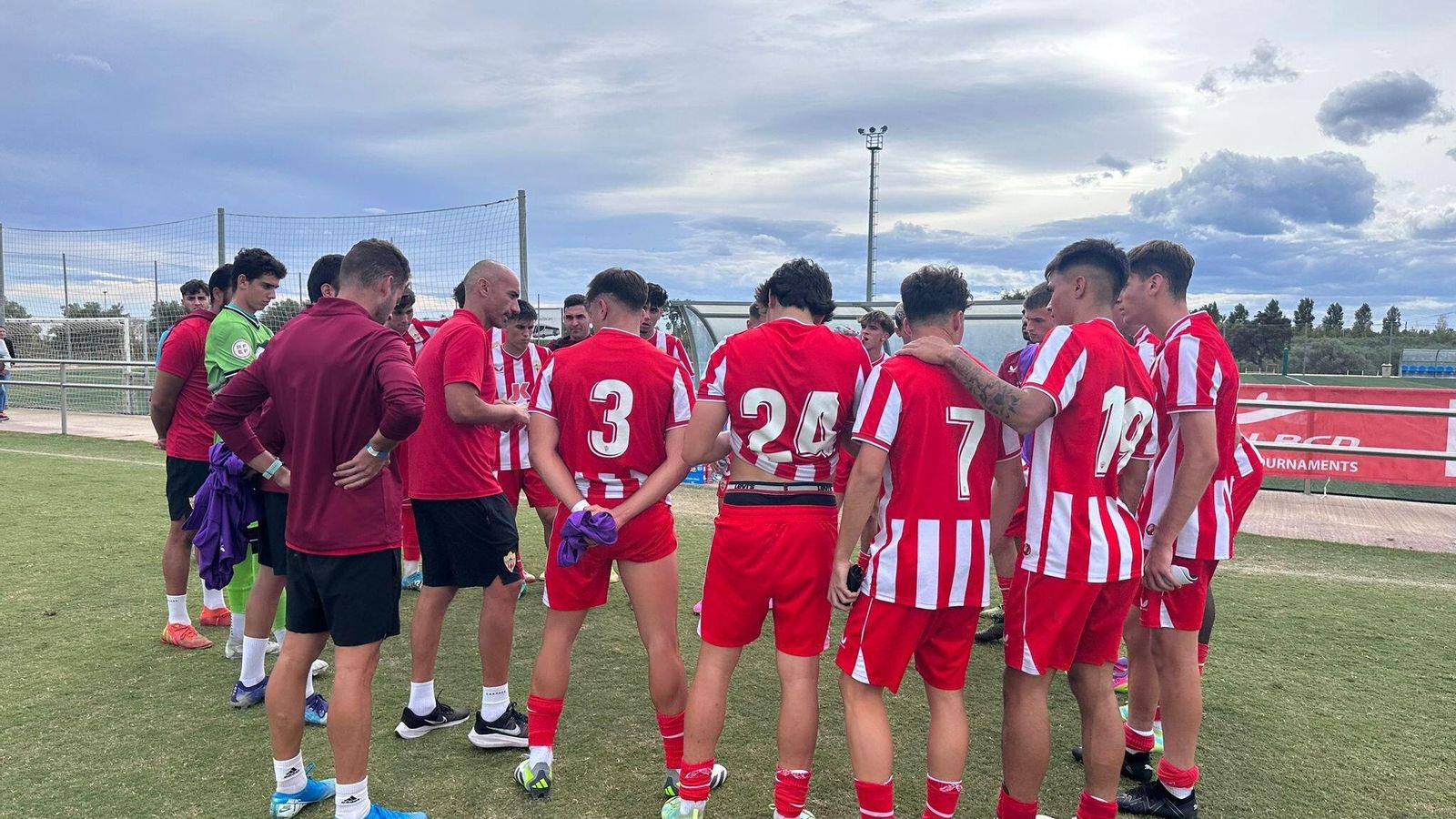 Los jugadores del juvenil rojiblanco escuchando las instrucciones de Zeus Carmona