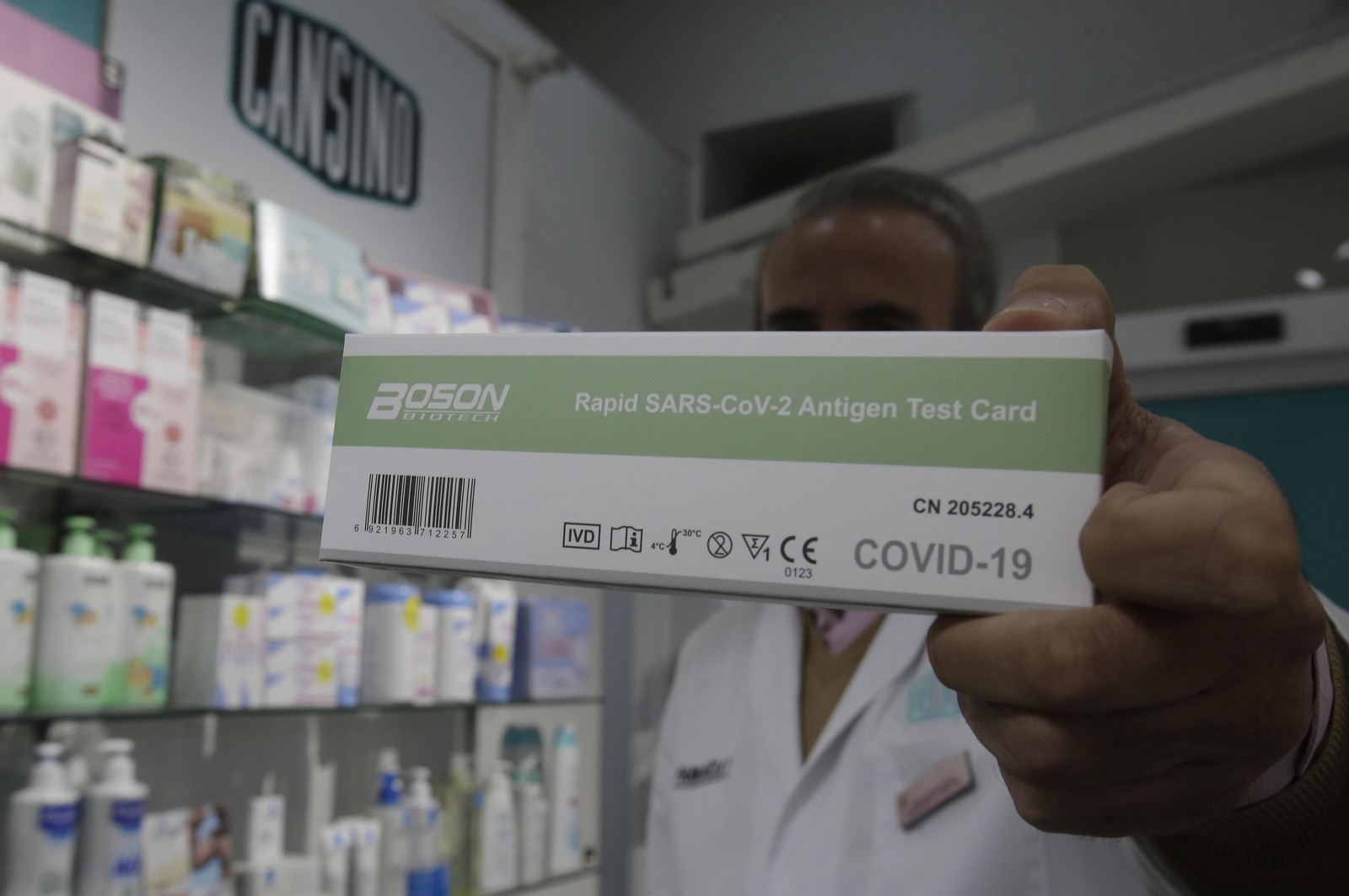 Un farmacéutico sostiene un test de antígenos Un farmacéutico sostiene un test de antígenos