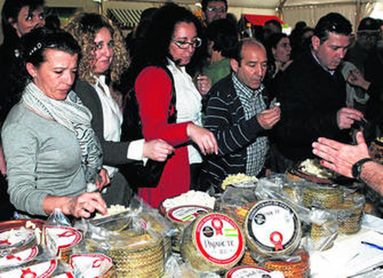 Degustación en el expositor de Quesos Pajarete, con sede en Villamartín, ayer en la feria de Villalluenga.