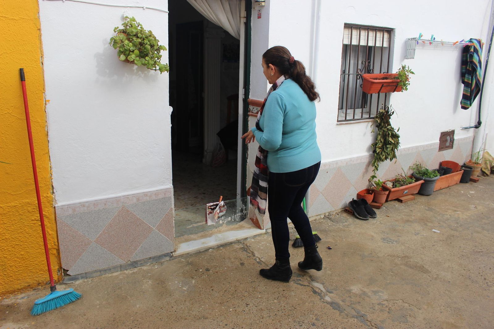 Isabel Moreno, vecina del barrio, termina de limpiar el agua que entró en su vivienda.