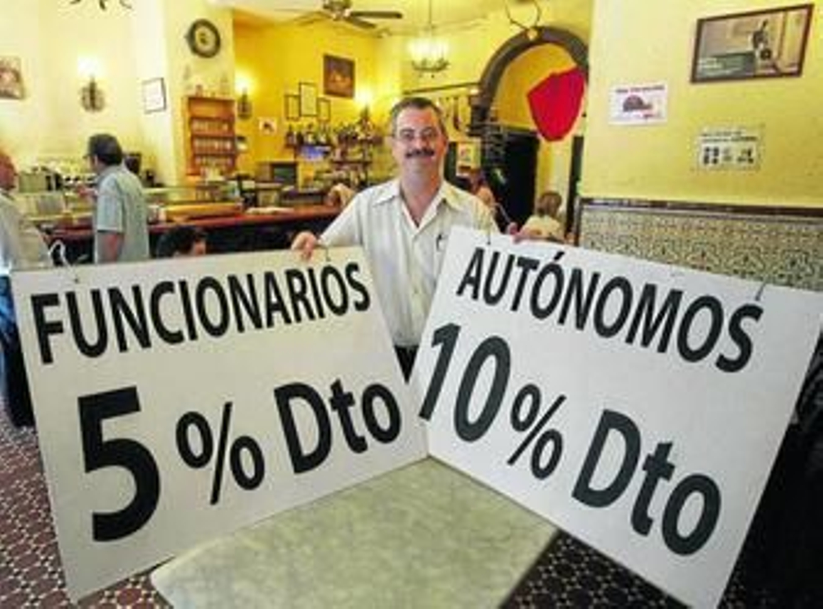 El encargado del mesón, con los carteles que anuncian los descuentos.