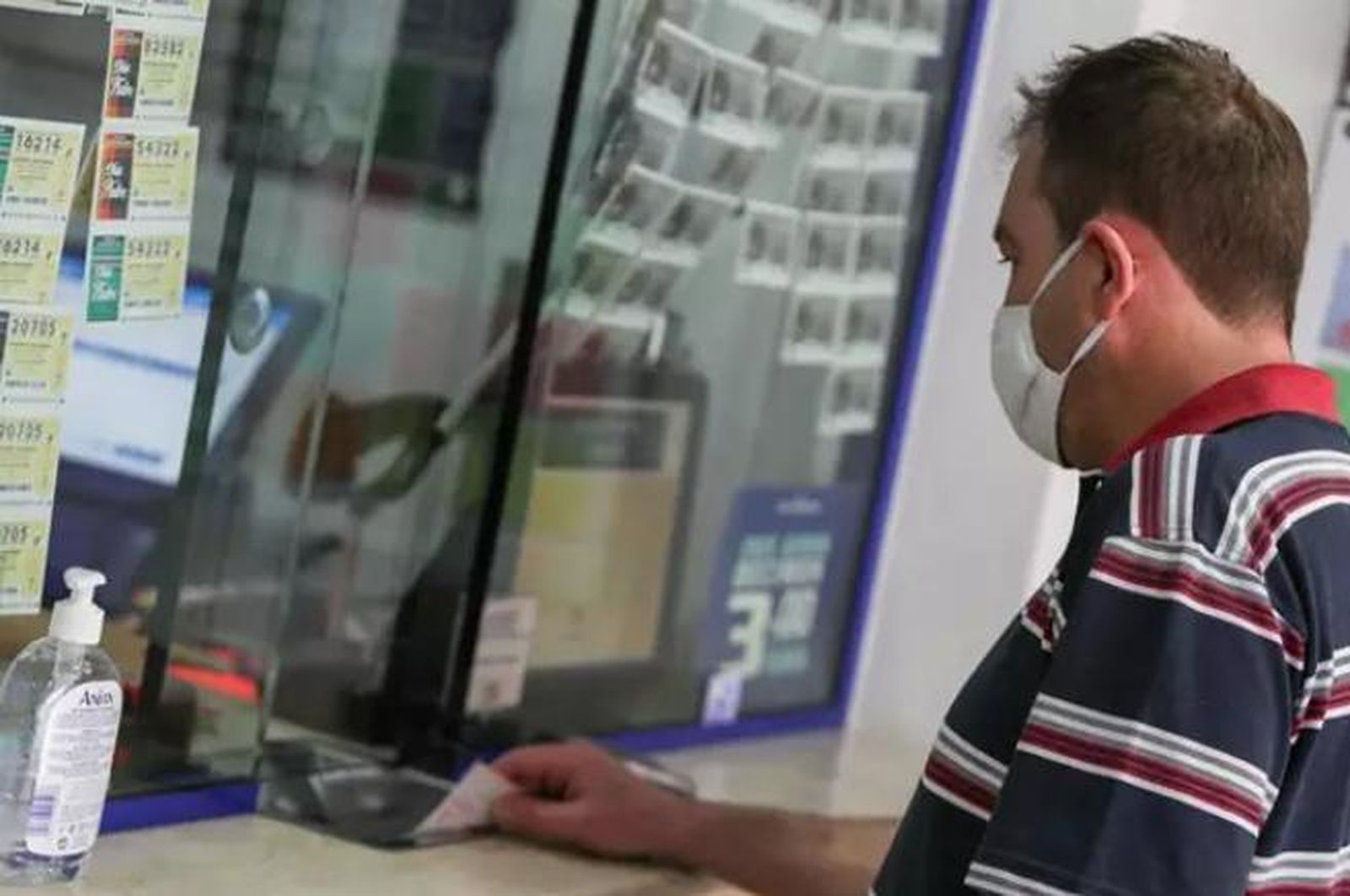 Un hombre compra lotería en una administración