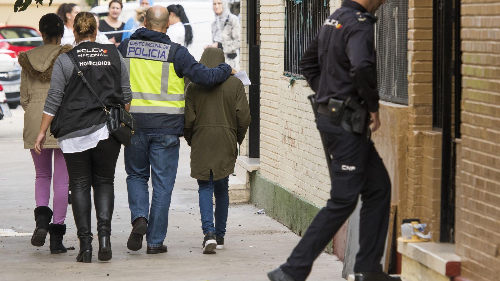 Un policía se lleva al hijo de la mujer asesinada en Los Pajaritos en octubre.