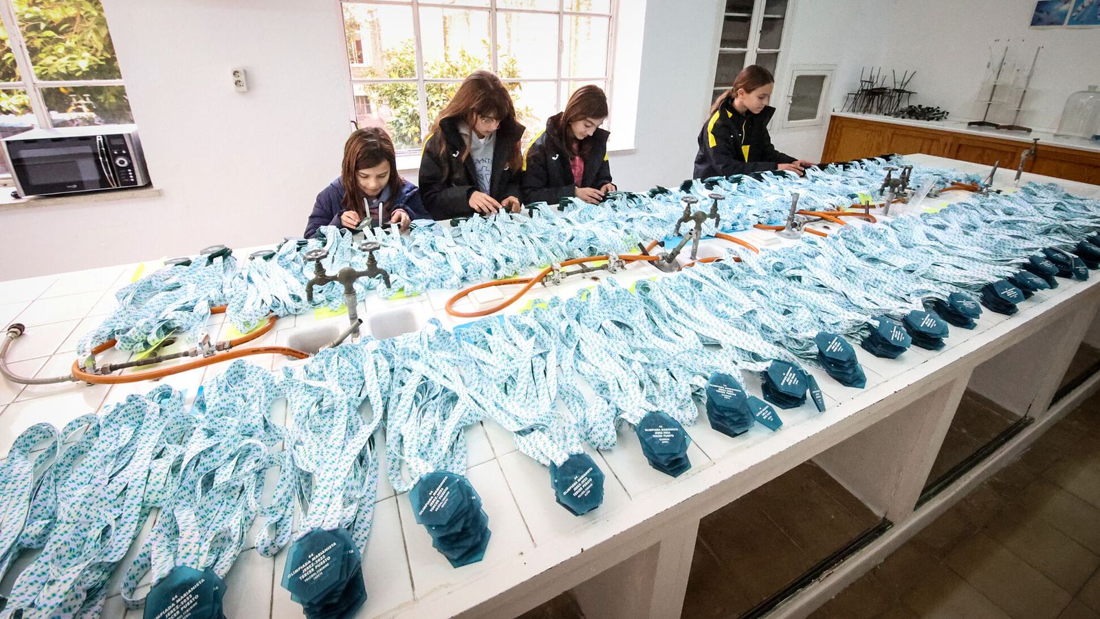 Varias voluntarias, preparando las medallas.