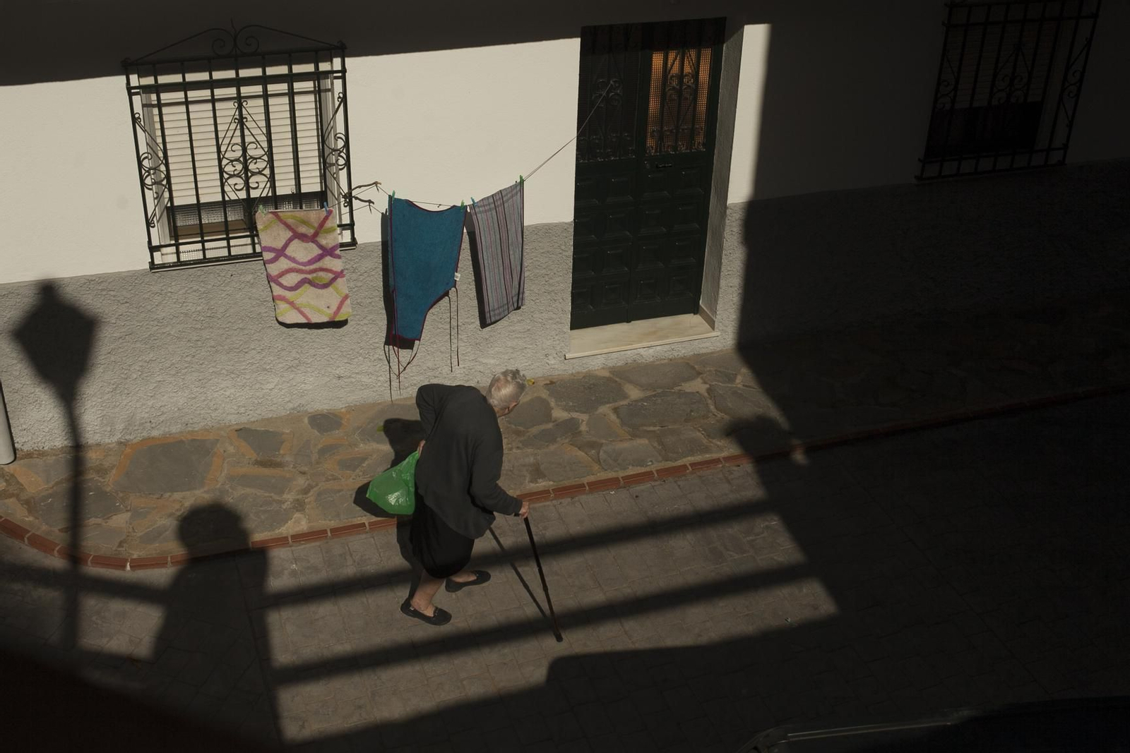 Una señora mayor pasea por una de las calles de Pujerra.