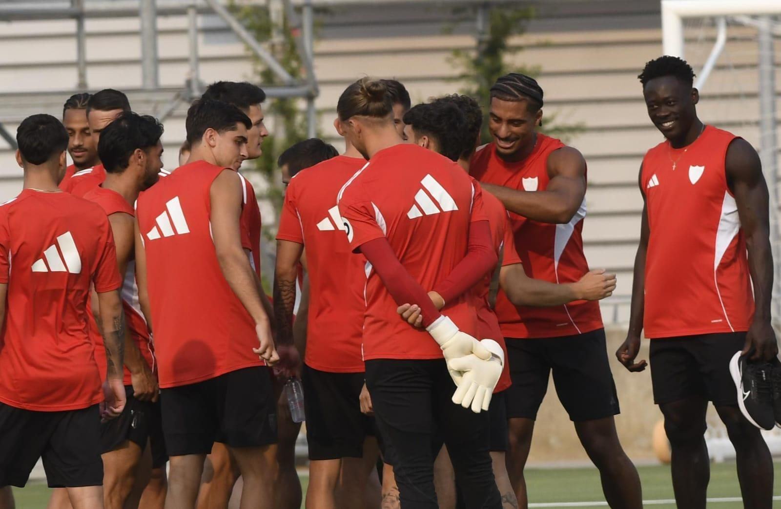 Badé se abraza a sus compañeros durante su último entrenamiento en el Sevilla, este martes.
