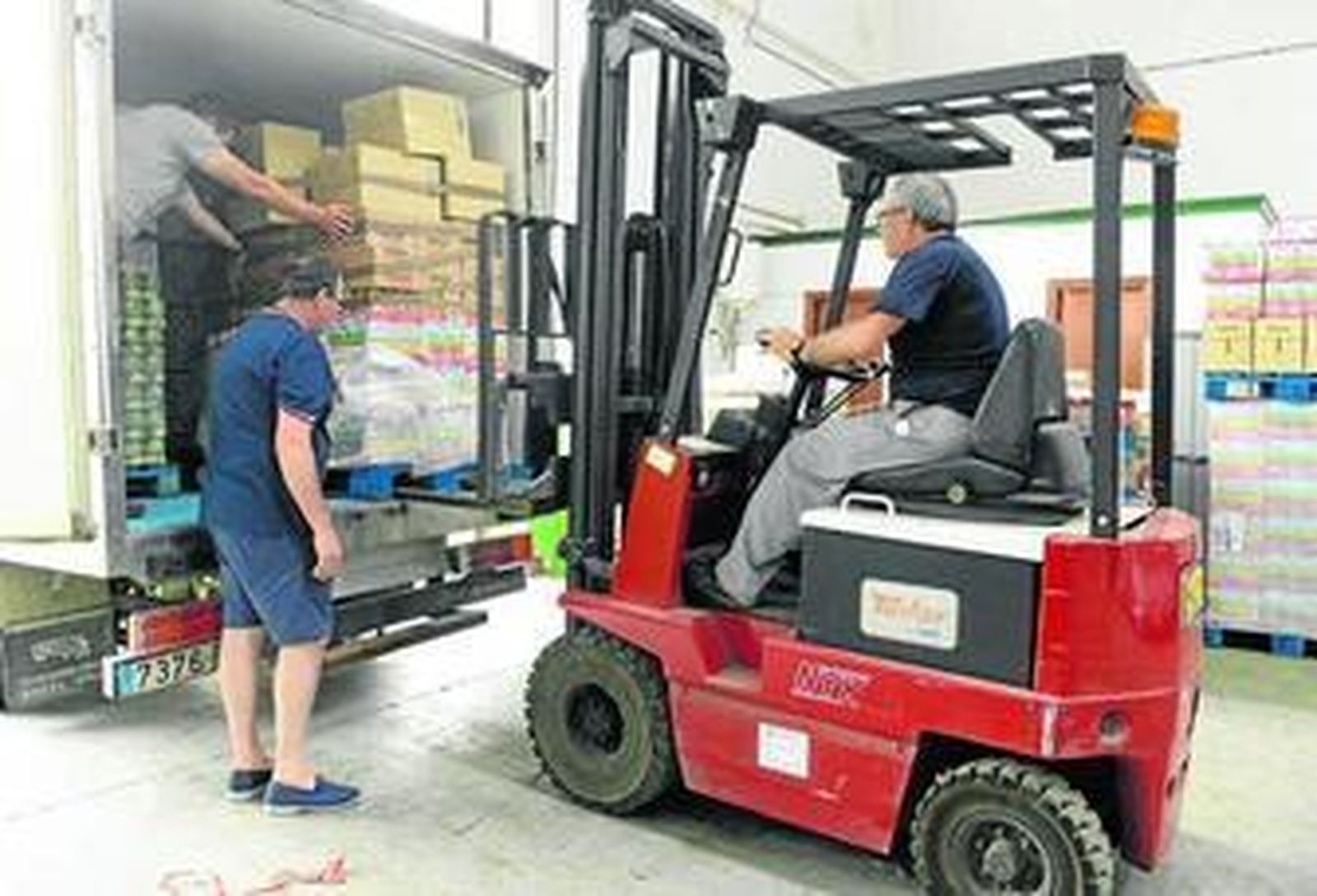Voluntarios del Banco de Alimentos ayudan a cargar víveres en un camión.